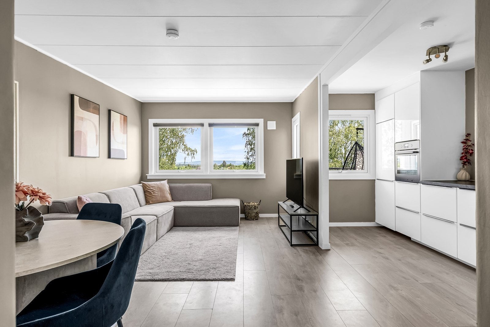 Stuen har en god planløsning med plass til både sofagruppe og spisebord, og har åpen løsning mot kjøkkenet.
Fotograf: Håvard Daae Rognli. Galleribilde