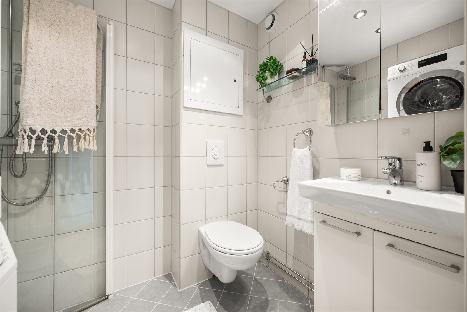 Badet er utstyrt med dusjhjørne med innfellbare dører, regnfallsdusj og rør-i-rør-system. Galleribilde