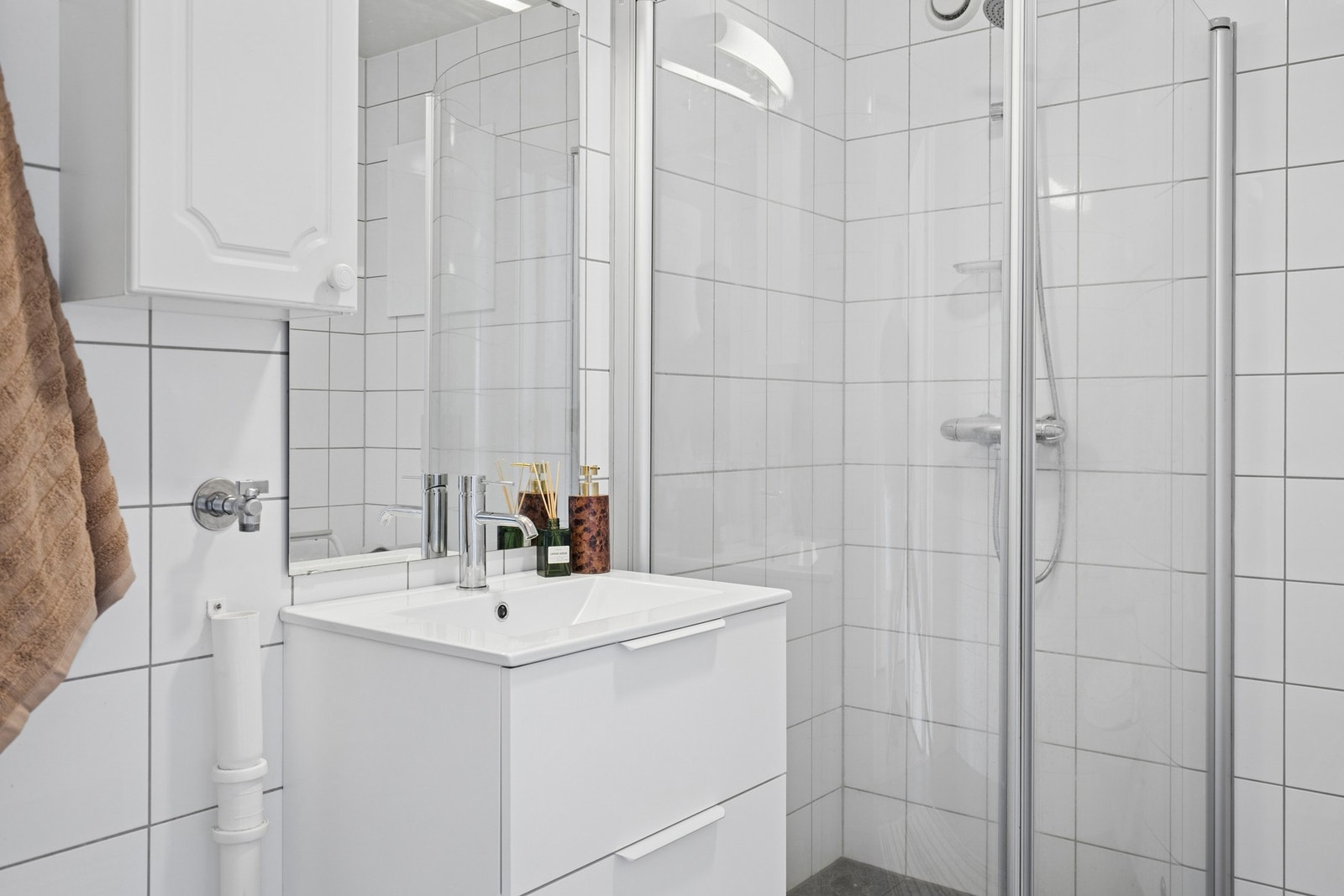 Baderomsinnredning med heldekkende servant, ettgreps blandebatteri og speil med belysning. Rommet har mekanisk avtrekk. Galleribilde