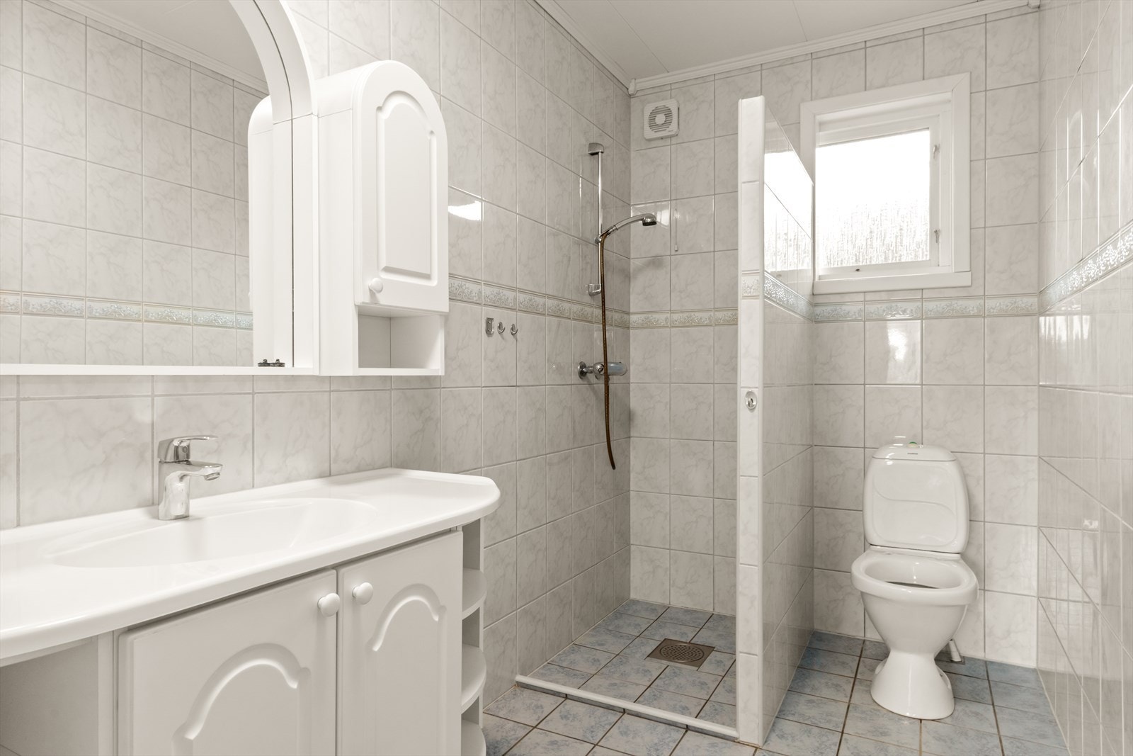 Badet er fra 2003 og er utstyrt med en praktisk dusjsone, toalett og en romslig servantinnredning med god skapplass. Galleribilde
