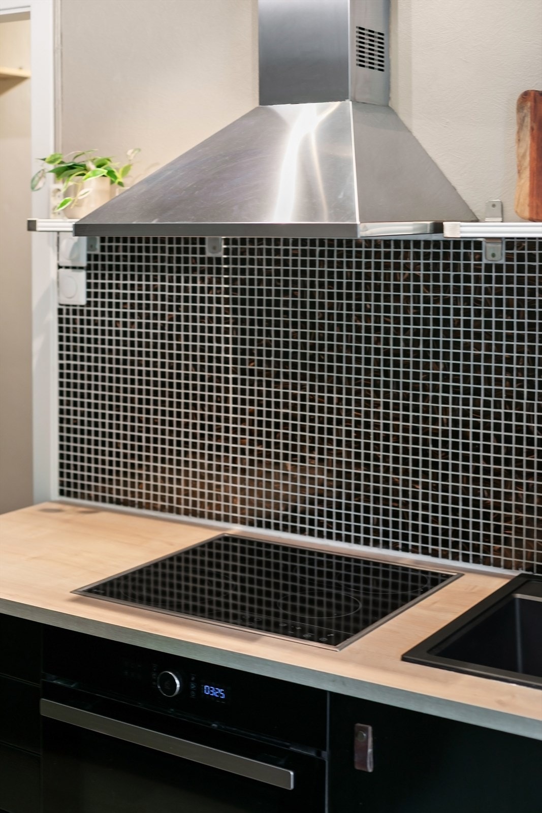 Mosaikkfliser på veggen over benken og ventilator med kullfilter. Galleribilde