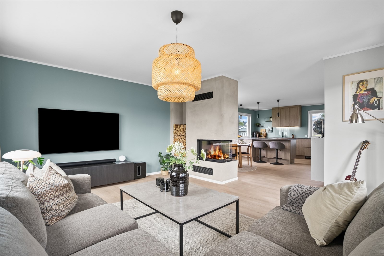 Stilren oppholdsavdeling med gjennomført materialvalg, moderne peis og åpen planløsning. Galleribilde