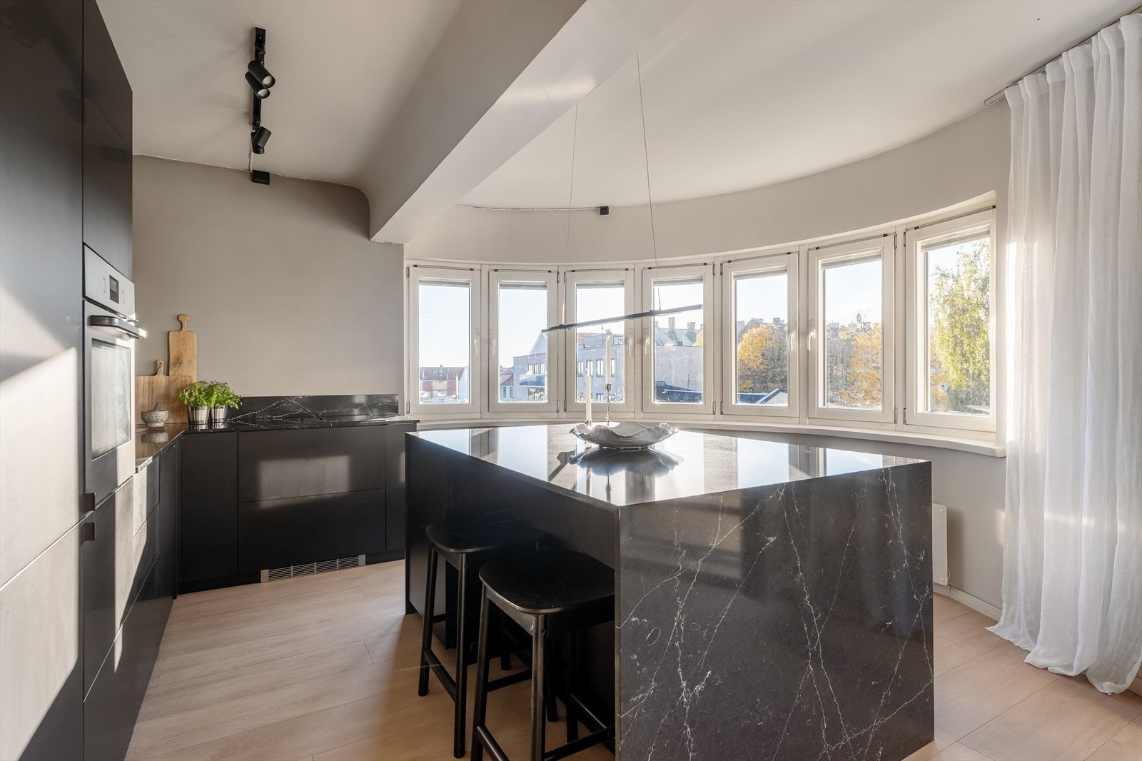 Kompositt-/quarts benkeplate - som går videre opp i backsplash og nedover den lekre kjøkkenøyen setter prikken over i'en. Galleribilde