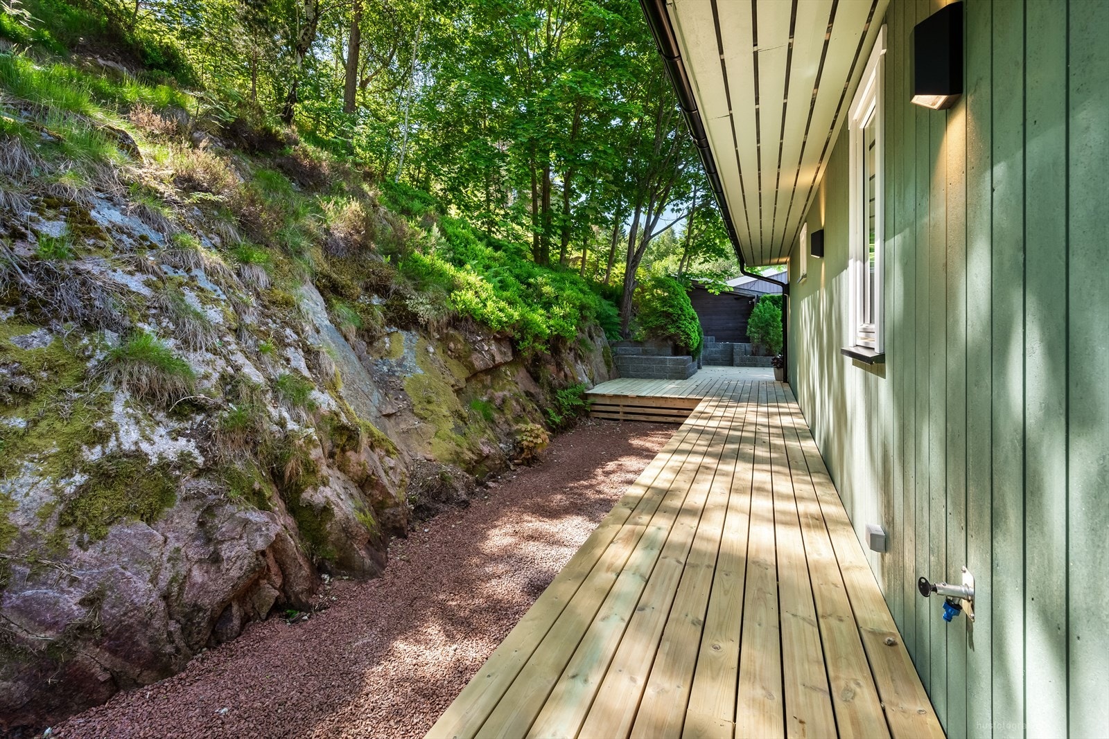 Den store terrassen strekker seg langs baksiden av huset og gir rikelig med uteplass. Galleribilde