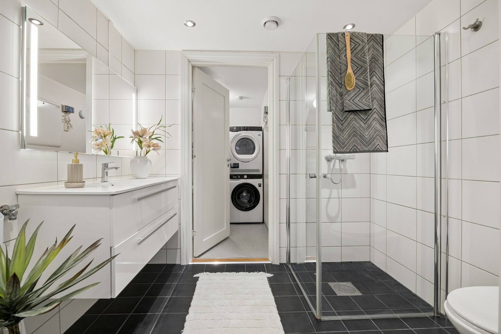 Badet har flislagt gulv med vannbåren varme og opplegg for vaskemaskin. Galleribilde
