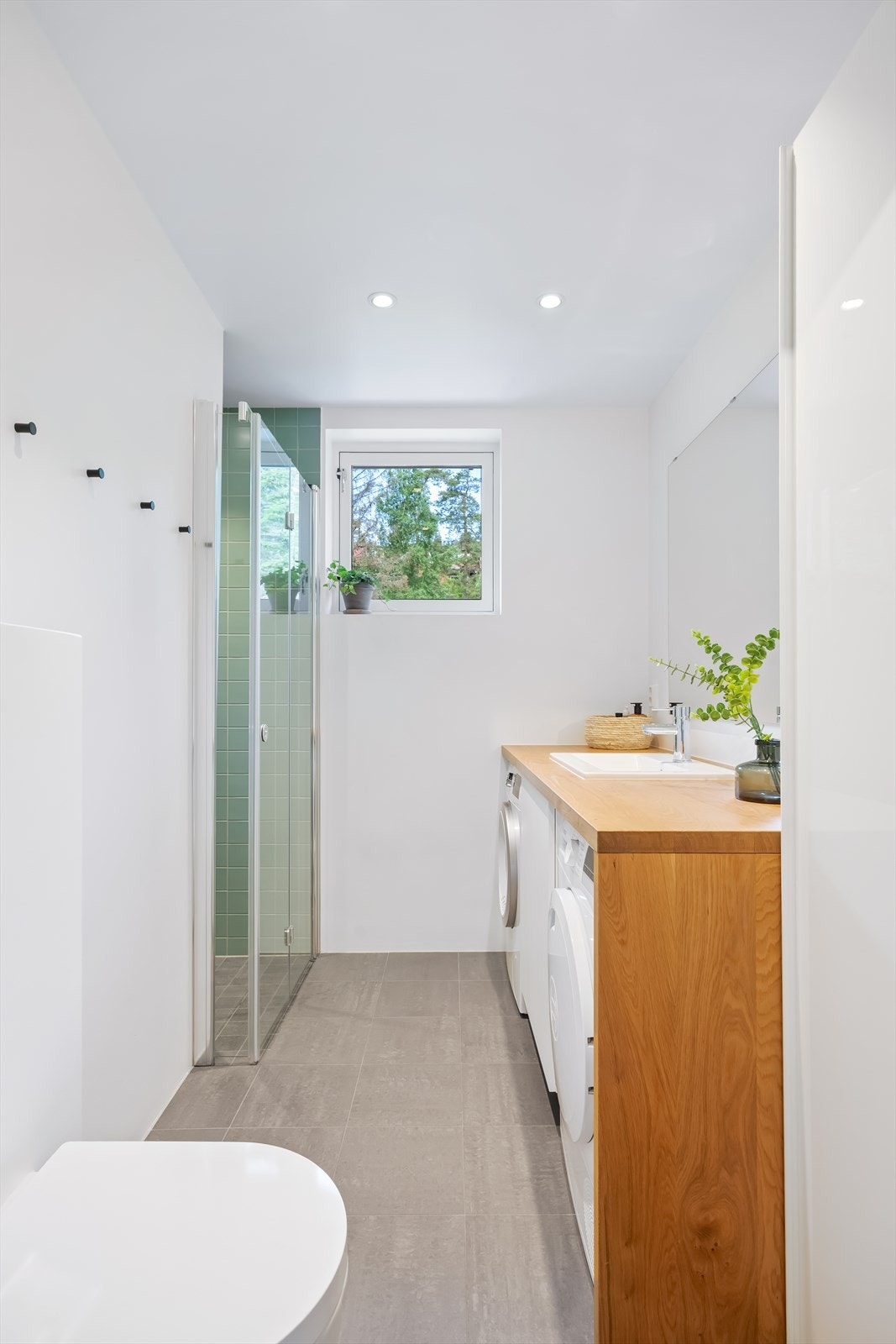 Badet ble modernisert i 2021 og har fliser på gulv med termostatstyrte varmekabler samt malte veggflater kombinert med fliser i dusjsonen. Galleribilde