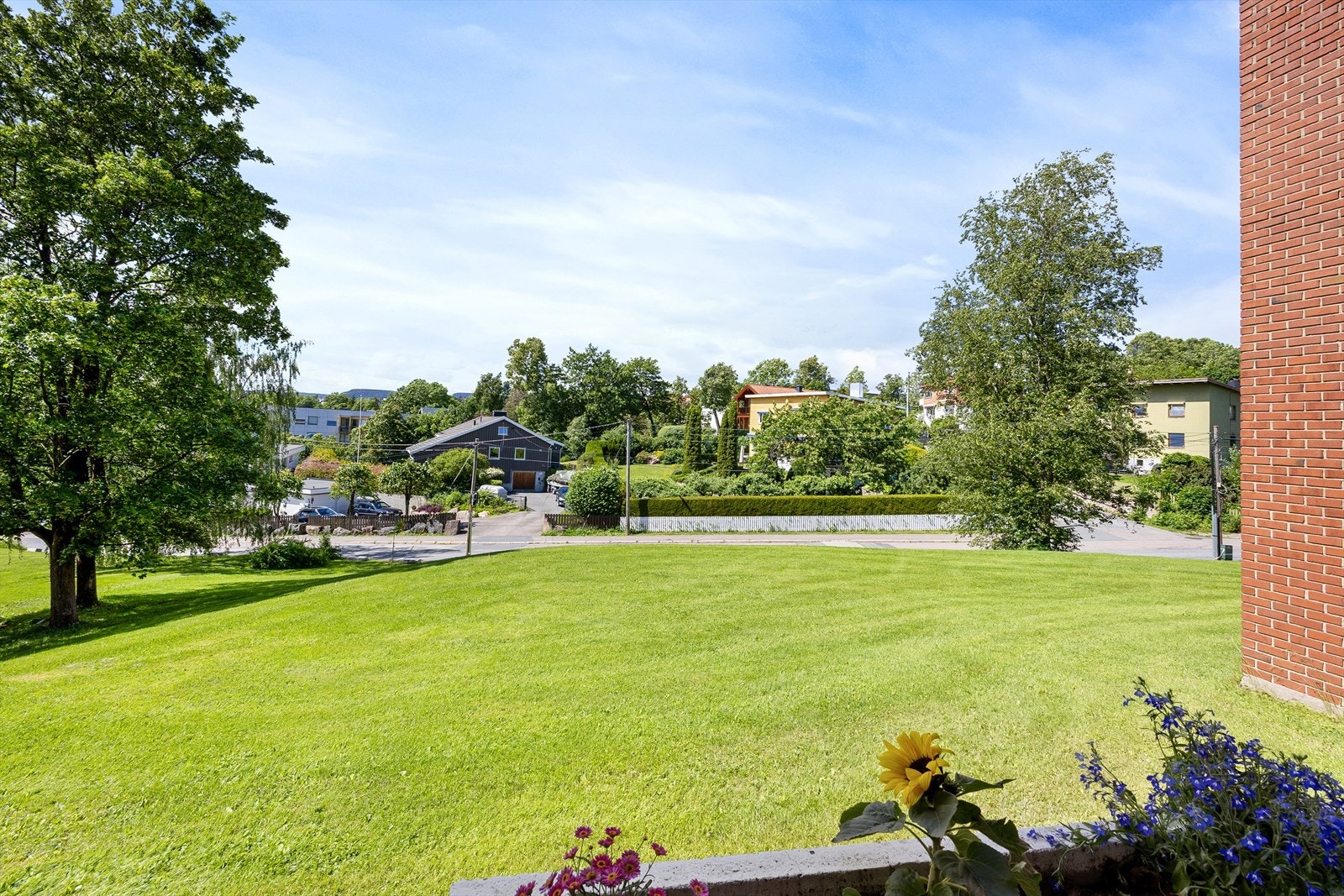 Fra balkongen er det et pent utsyn over de store, grønne fellesarealene som omkranser bygget. Galleribilde