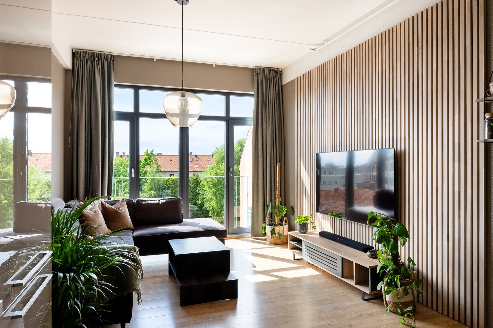 Moderne overflater med laminat på gulv og malte flater kombinert med pen spilevegg i stuen. Galleribilde