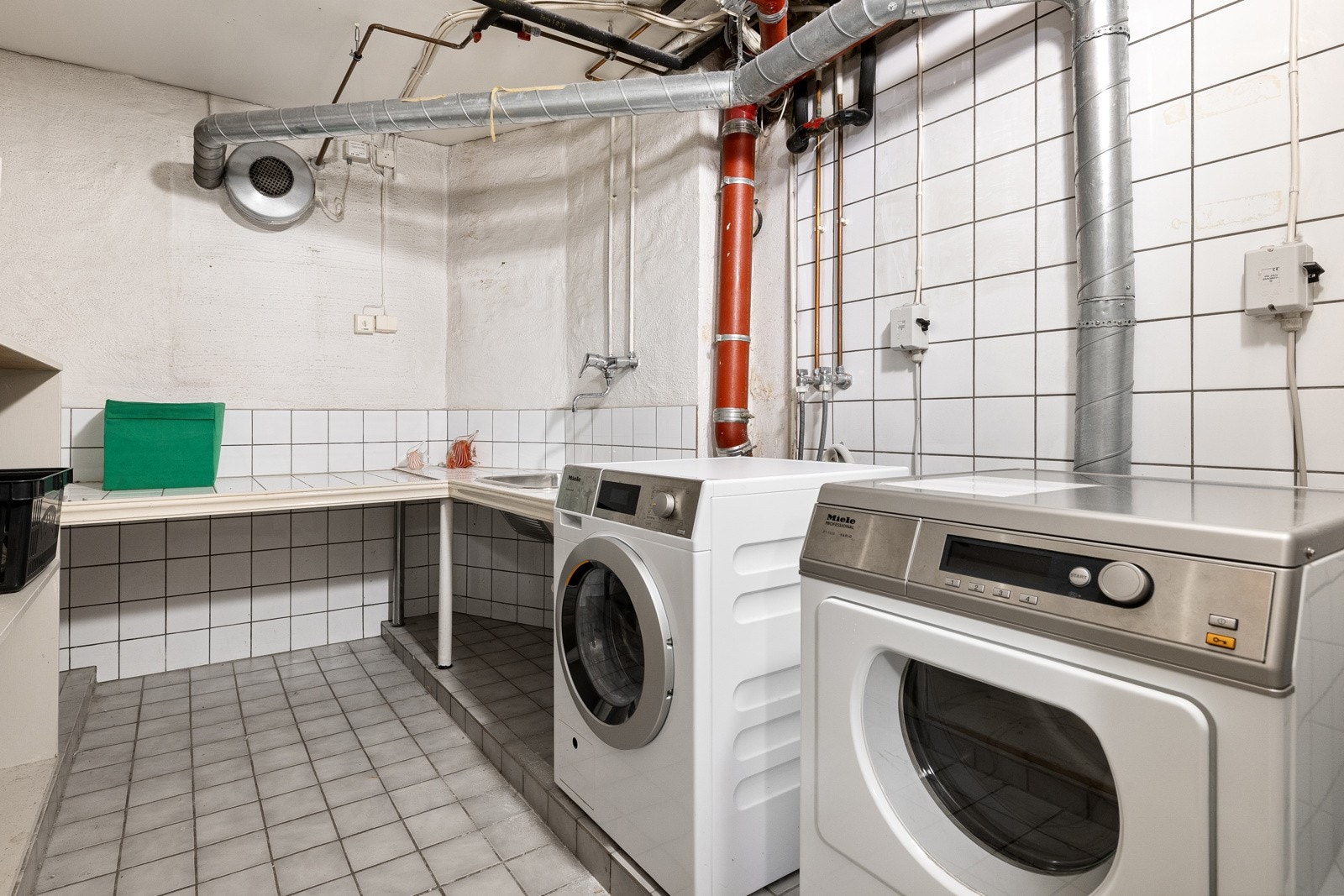 Fellesvaskeriet i kjelleren inneholder vaskemaskin og tørketrommel i tillegg til skyllekum. Galleribilde