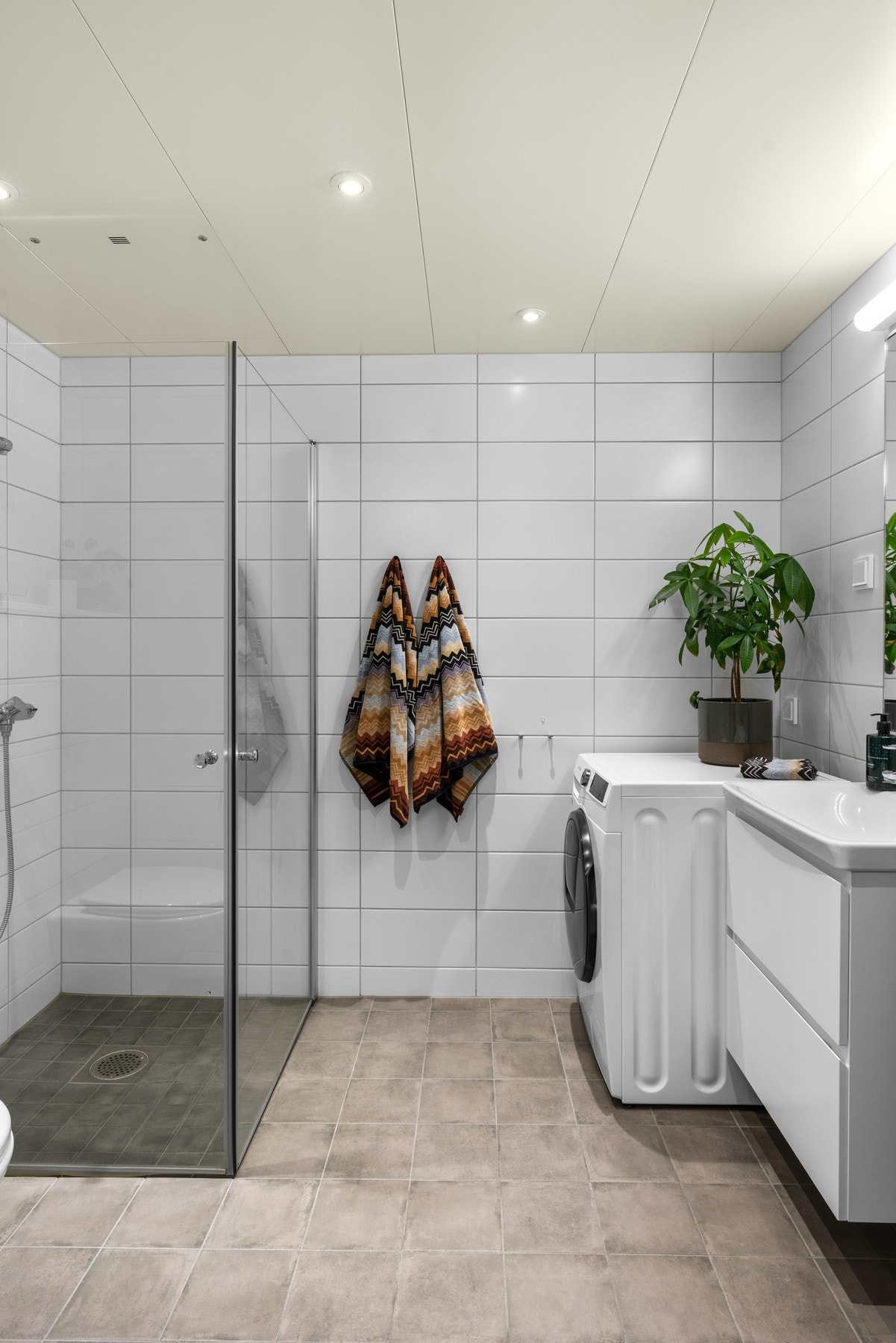 Stilrent bad fra 2021 med downlights, gulvvarme og opplegg for både vaskemaskin og tørketrommel. Galleribilde