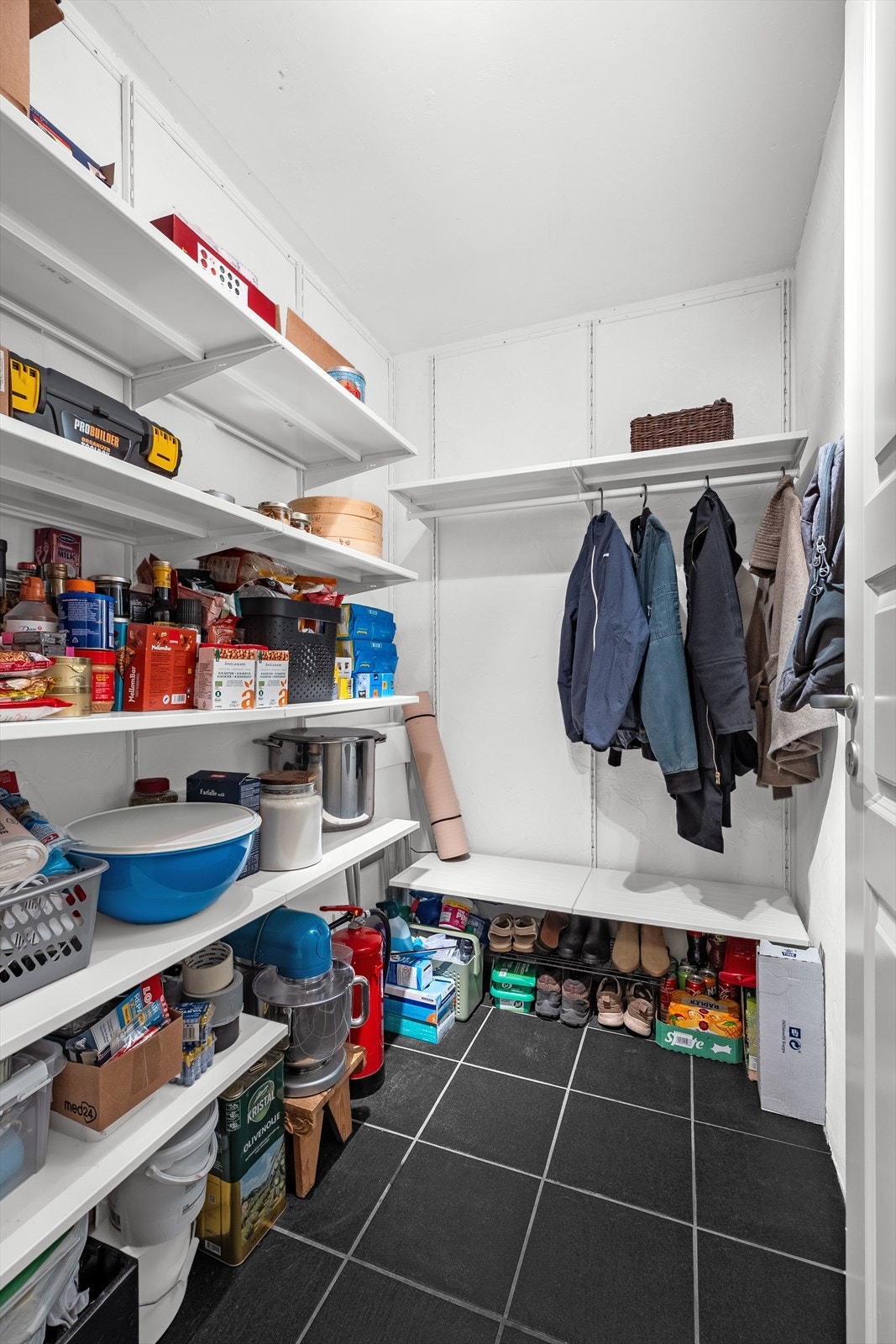 Boden har hyller langs veggene og hengestang for yttertøy. Galleribilde