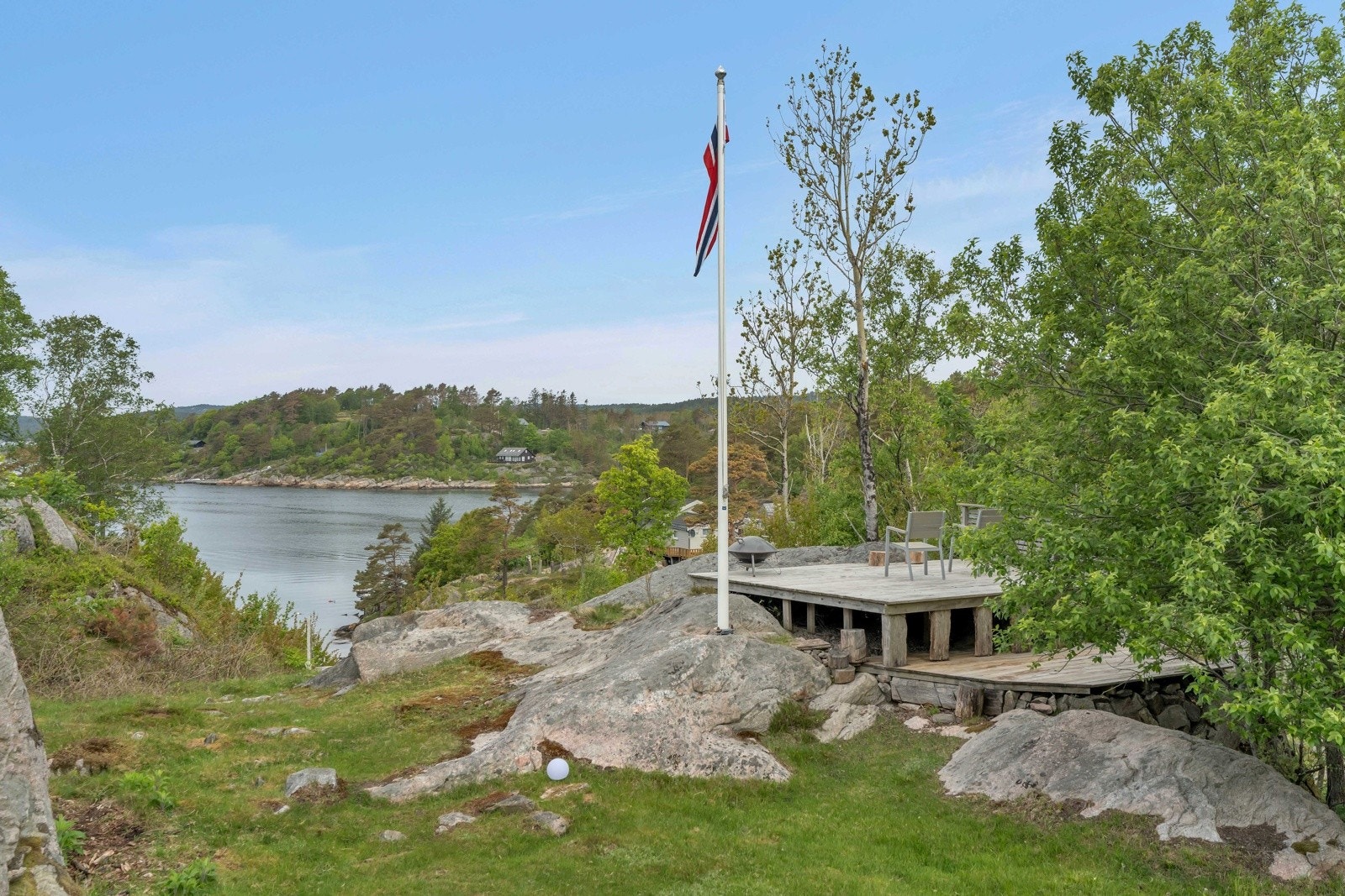 Tomten er pent opparbeidet med plen og terrasse på baksiden av hytten. Galleribilde