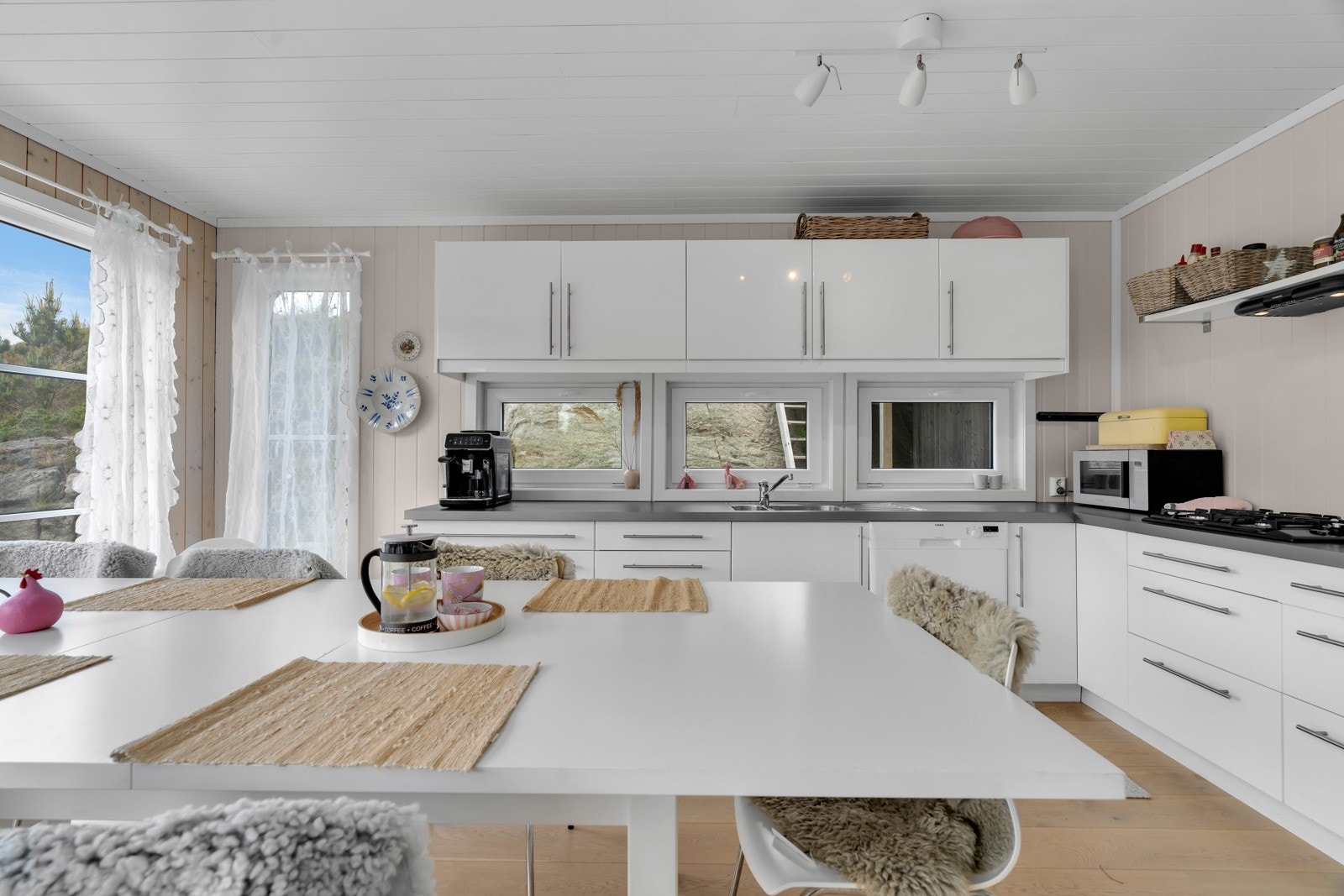 Det er lyst enstavs eikeparkett på gulv og panelplater på veggene på kjøkkenet. Galleribilde