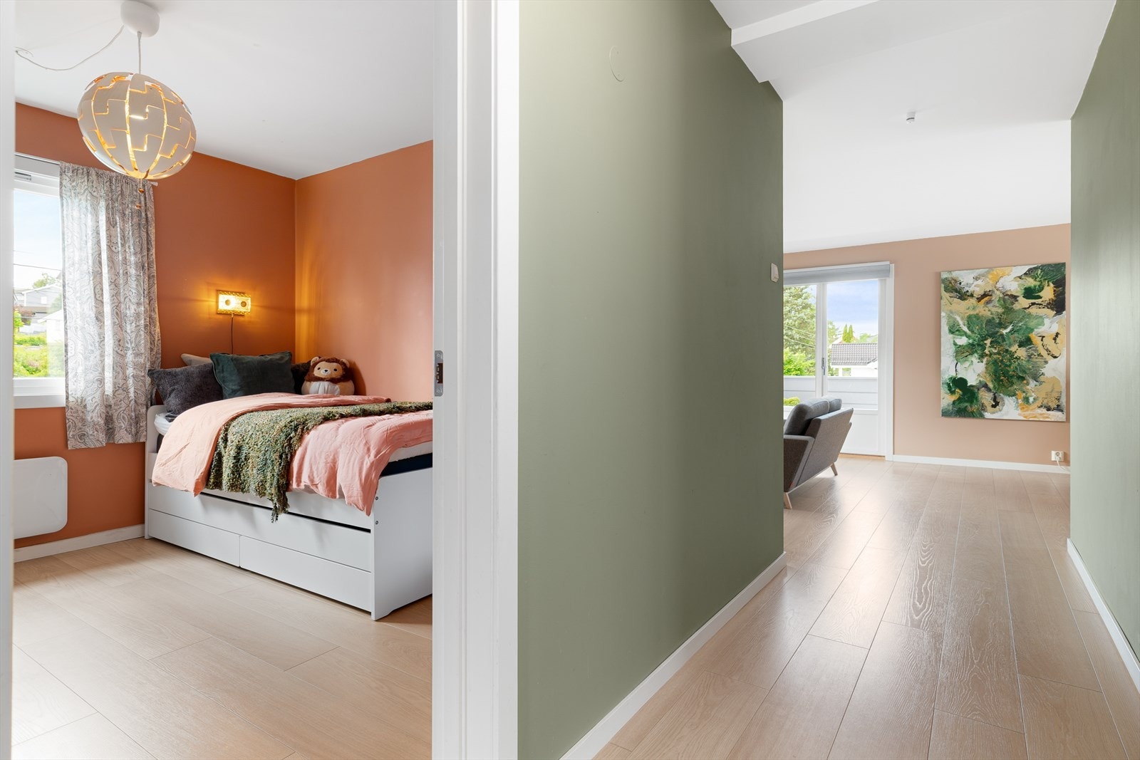 Soverom 2 fremstår som et lyst og innbydende rom med samme flotte gulv som resten av boligen. De glatte, malte overflatene i en stilren fargetone skaper en rolig og behagelig atmosfære. Galleribilde