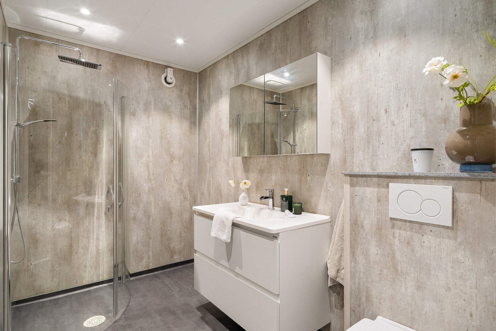 Badet ligger i 1. etasje og har et moderne uttrykk, med baderomsplater på vegg, vinylbelegg på gulv og varmekabler. Galleribilde