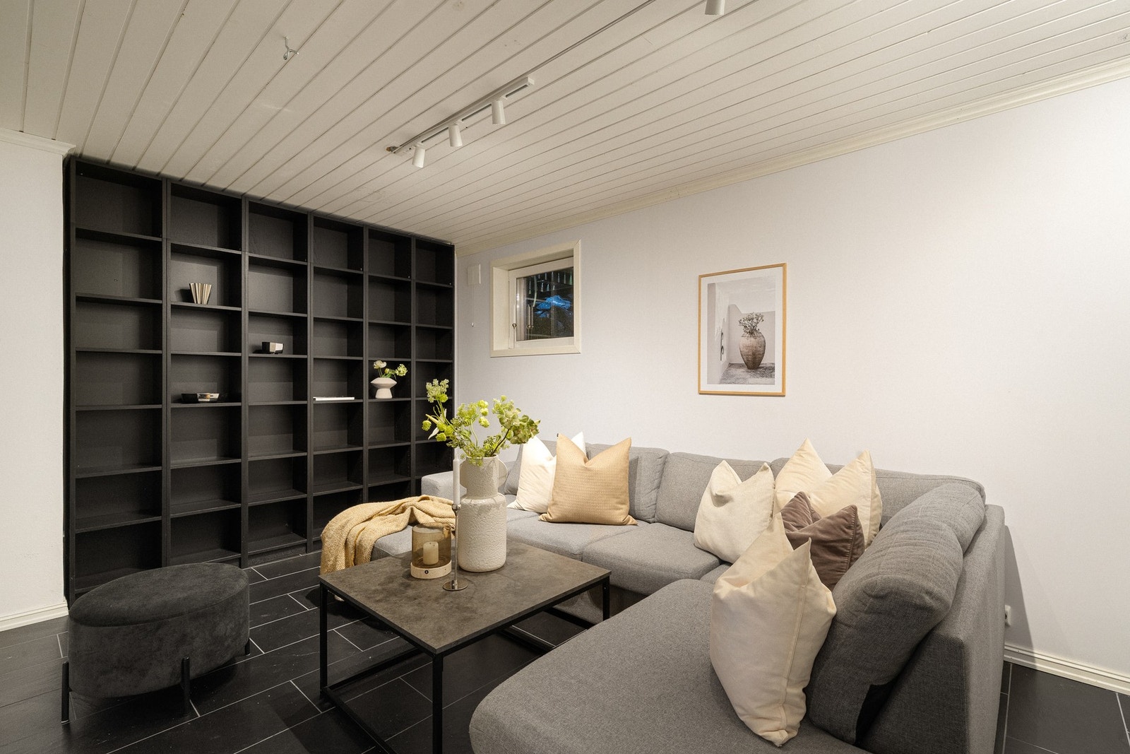 I 1. etasje finnes i tillegg en kjellerstue/oppholdsrom med mørke fliser og plassbygd hylleløsning. Galleribilde