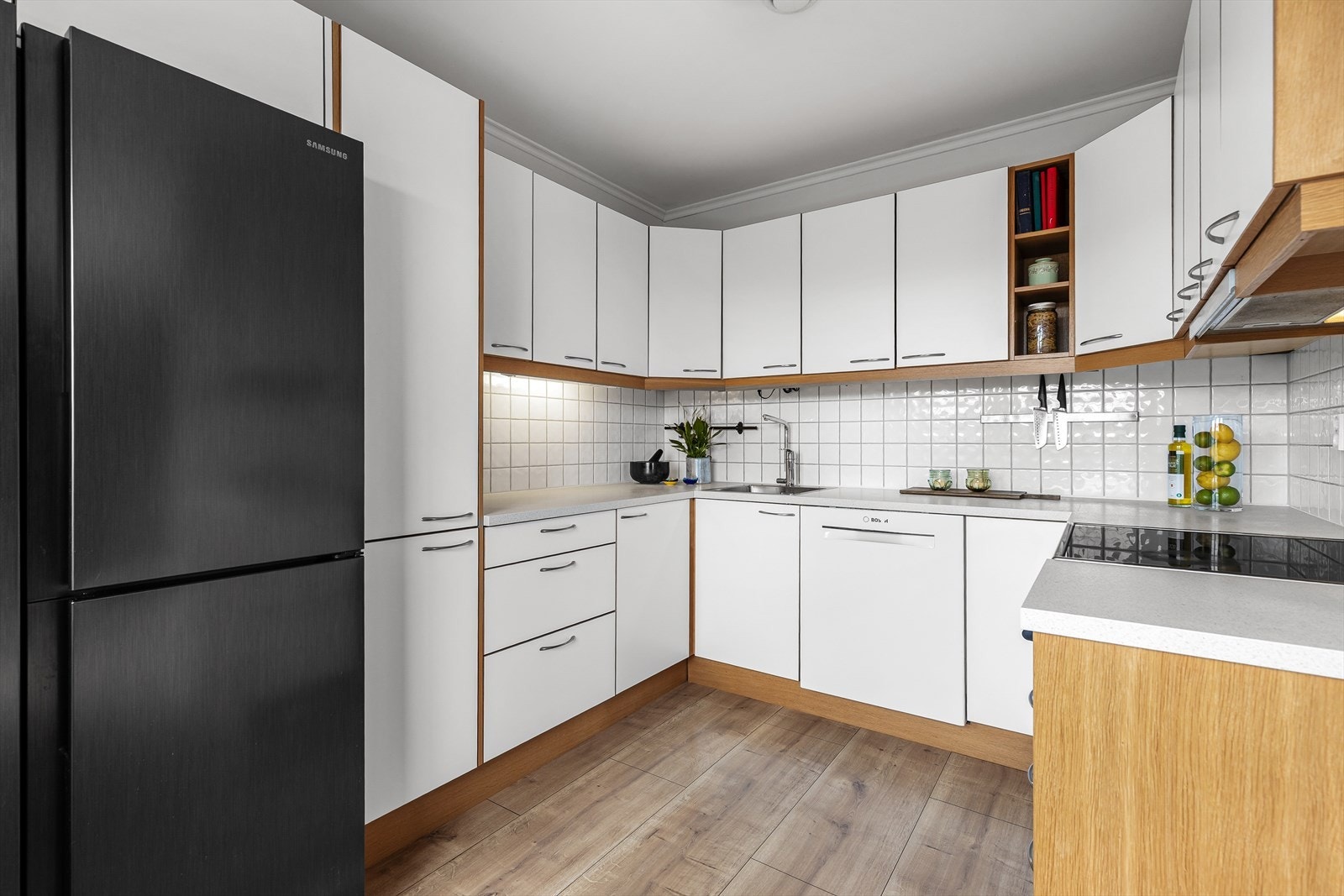 Kjøkkeninnredning med glatte fronter og laminatbenkeplate. Fronter og benkeplate ble fornyet i 2020. Galleribilde