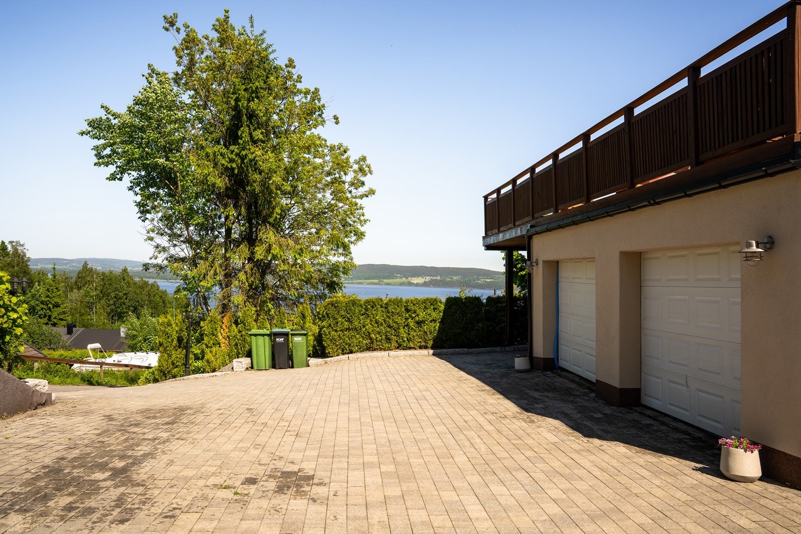 Uteområdet er pent opparbeidet med steinbelagt gårdsplass, hekk, og kunstgress. Galleribilde