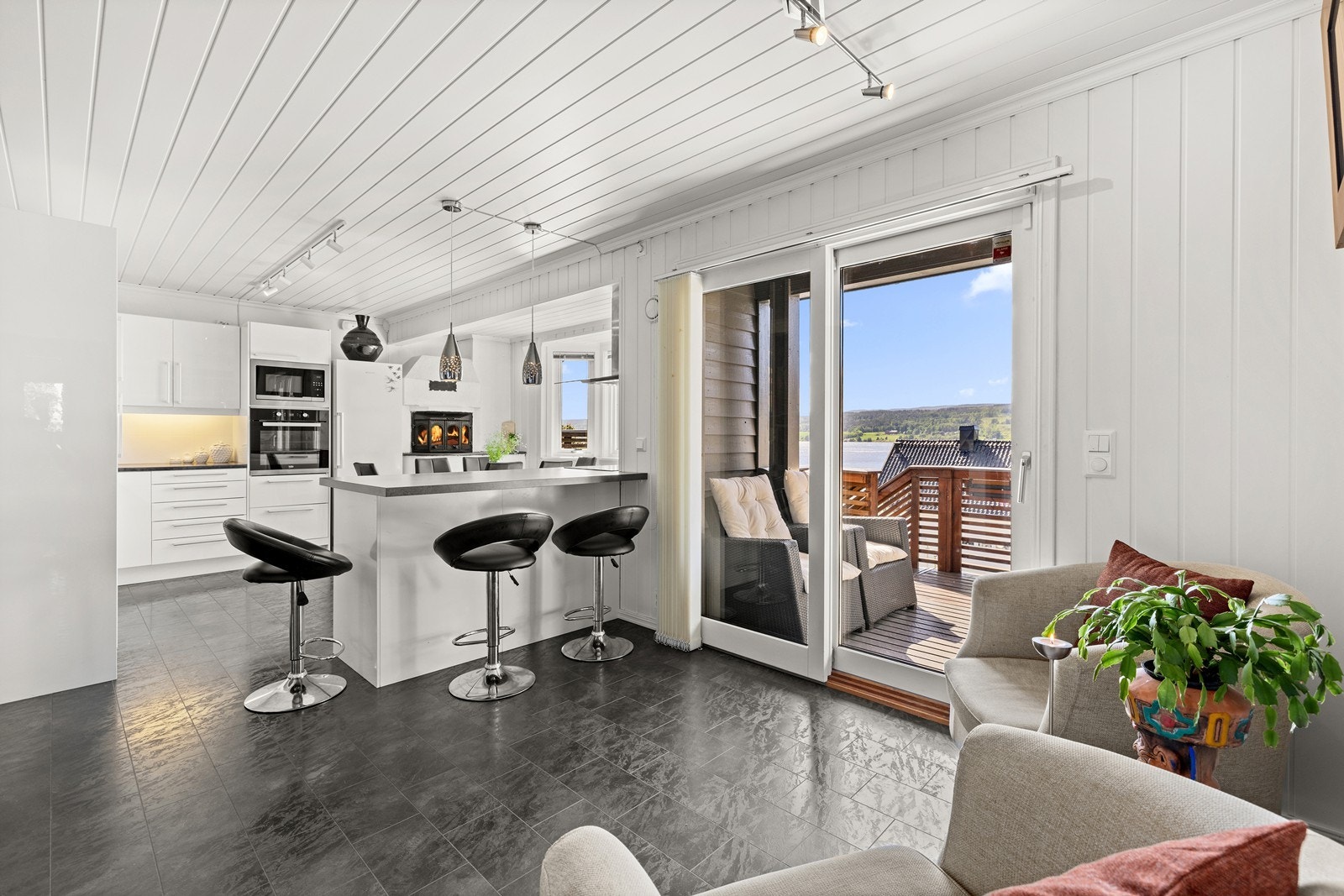 Fra kjøkkenet er det direkte utgang til en av boligens terrasser via en skyvebalkongdør. Galleribilde