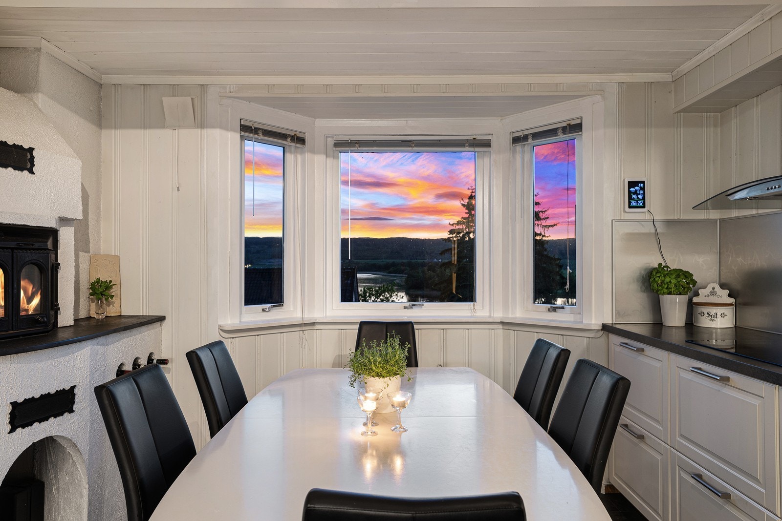 Spiseplassen ved karnappvinduet rammes inn av en stemningsfull peis med innsats. Galleribilde