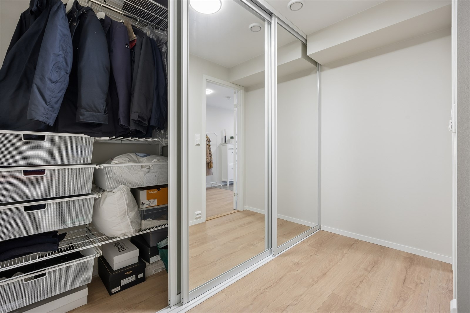 Vegg i vegg ligger en innredet bod som fungerer som walk-in-garderobe, med skyvedørsløsning og gode oppbevaringsmuligheter. Galleribilde