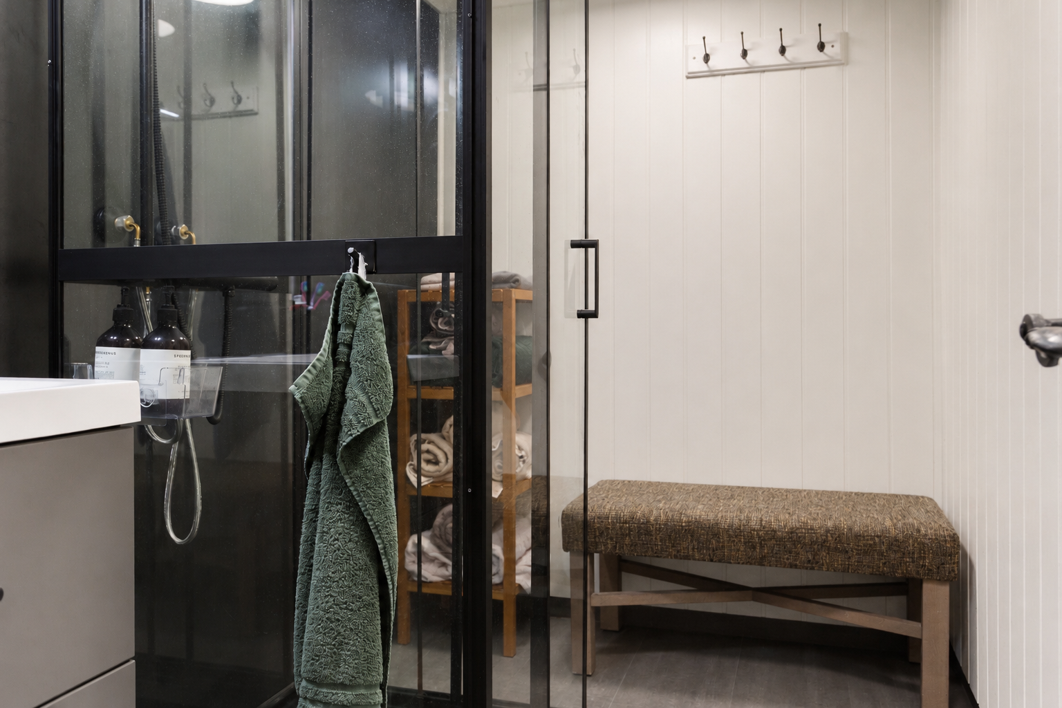 Badet er praktisk og funksjonelt innredet med materialer tilpasset hyttelivet. Rommet har servantinnredning med skuffer, heldekkende servant og dusjkabinett. Veggene er kledd med våtromsplater, som fungerer som godkjent membran- og tettesjikt. Galleribilde
