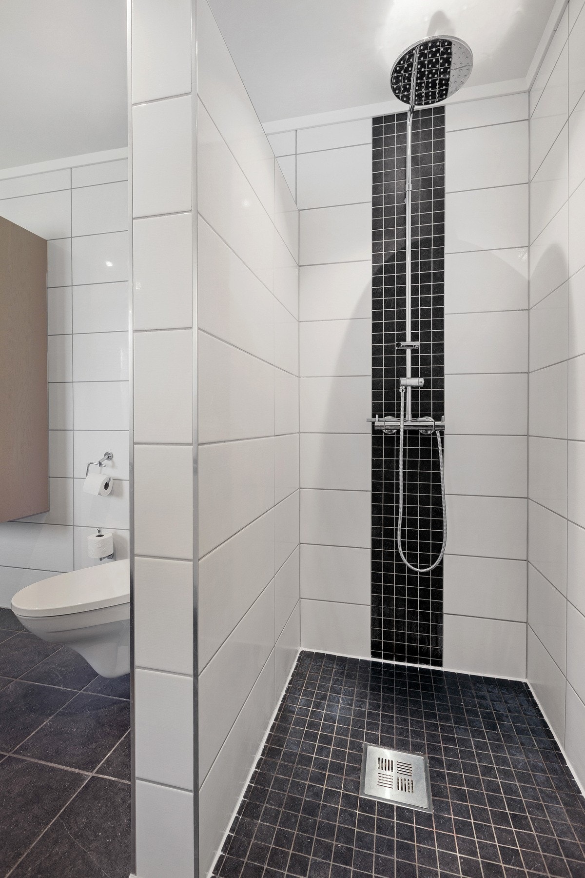 Badet i 1. etasjen er innredet med dusjnisje og vegghengt dusjutstyr. Galleribilde