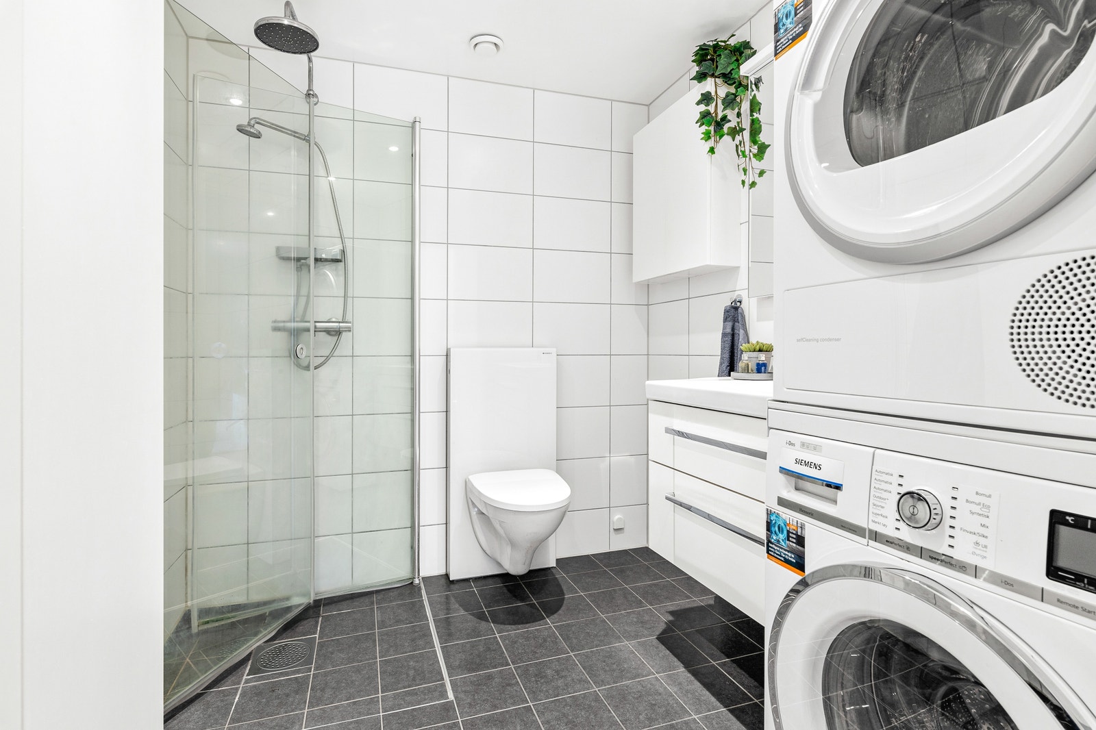 Moderne elegant flislagt bad. Med Integrerte takspotter. Vegg og 2 Høyeskap. Plass til vaskemaskin og tørketrommel. Galleribilde