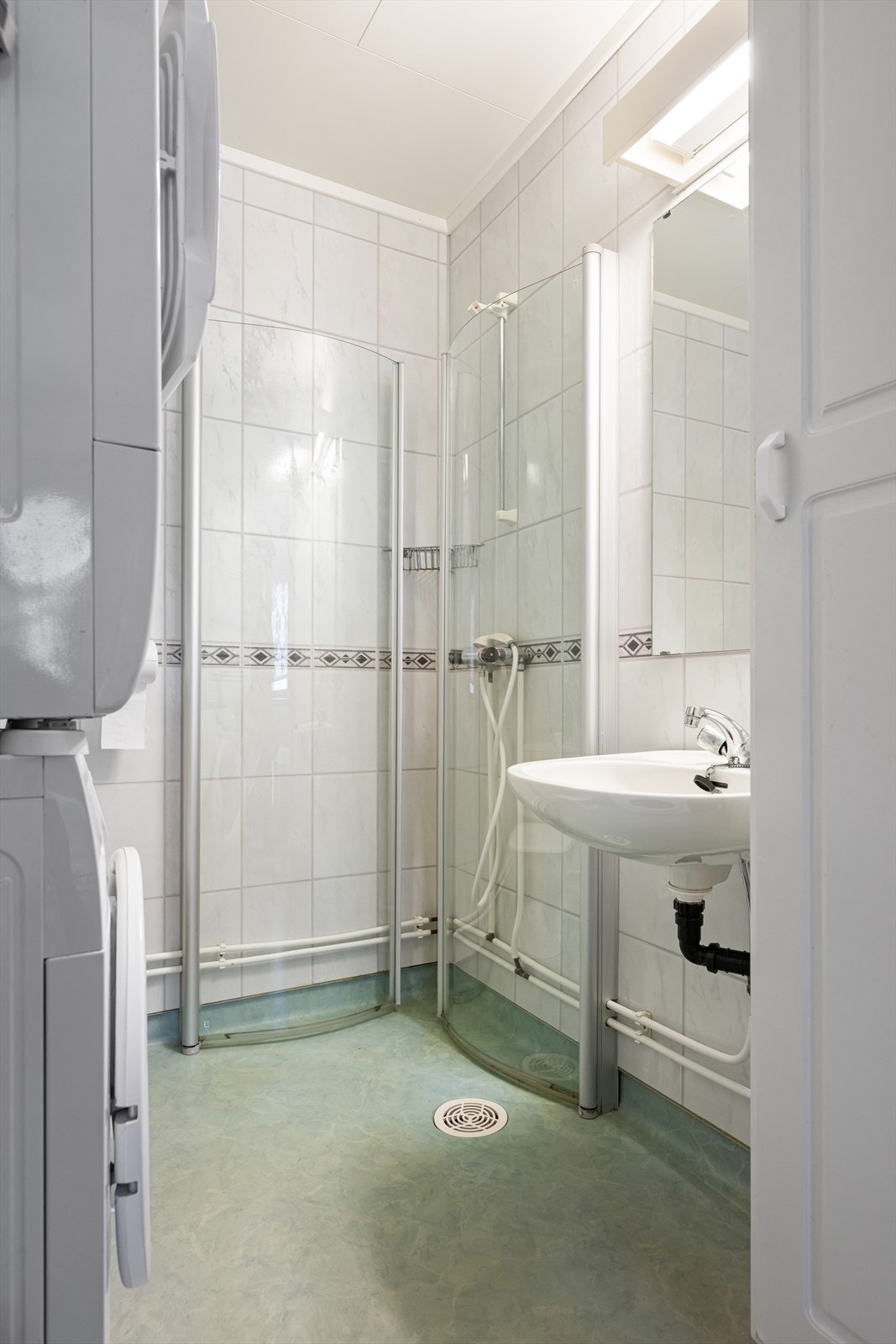 Badet er utstyrt med dusjhjørne, toalett, enkel servant og opplegg for vaskemaskin/tørketrommel. Galleribilde
