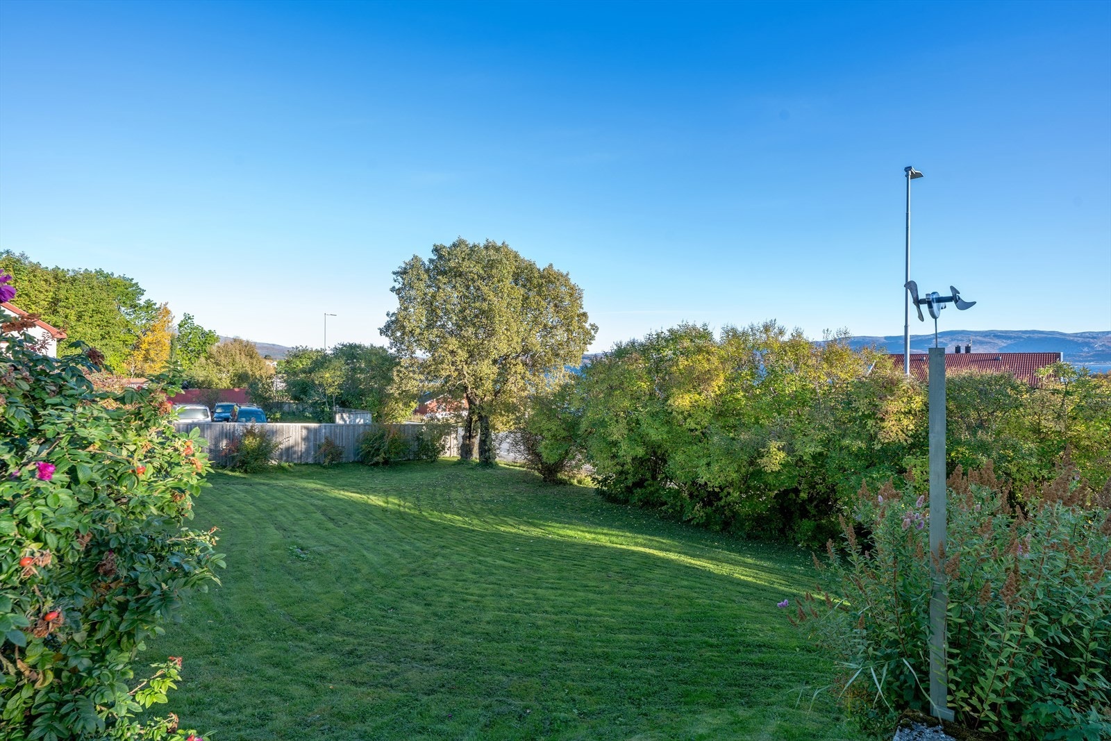 Tomten er opparbeidet med plen og beplantning, og gir fine uteområder rundt boligen. Galleribilde