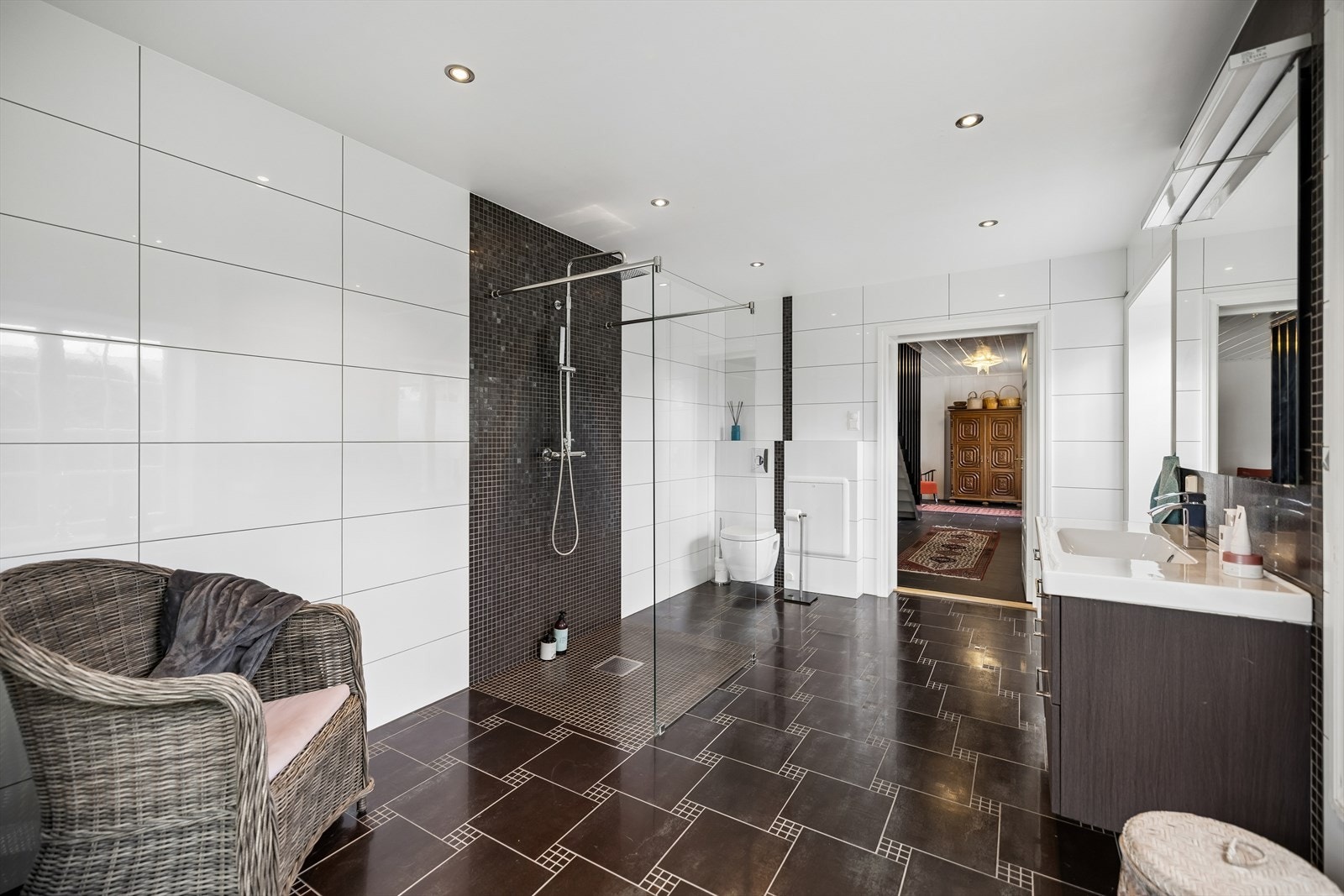 Badet har vegghengt toalett, dusj med rette glassdører og downlights i taket. Galleribilde