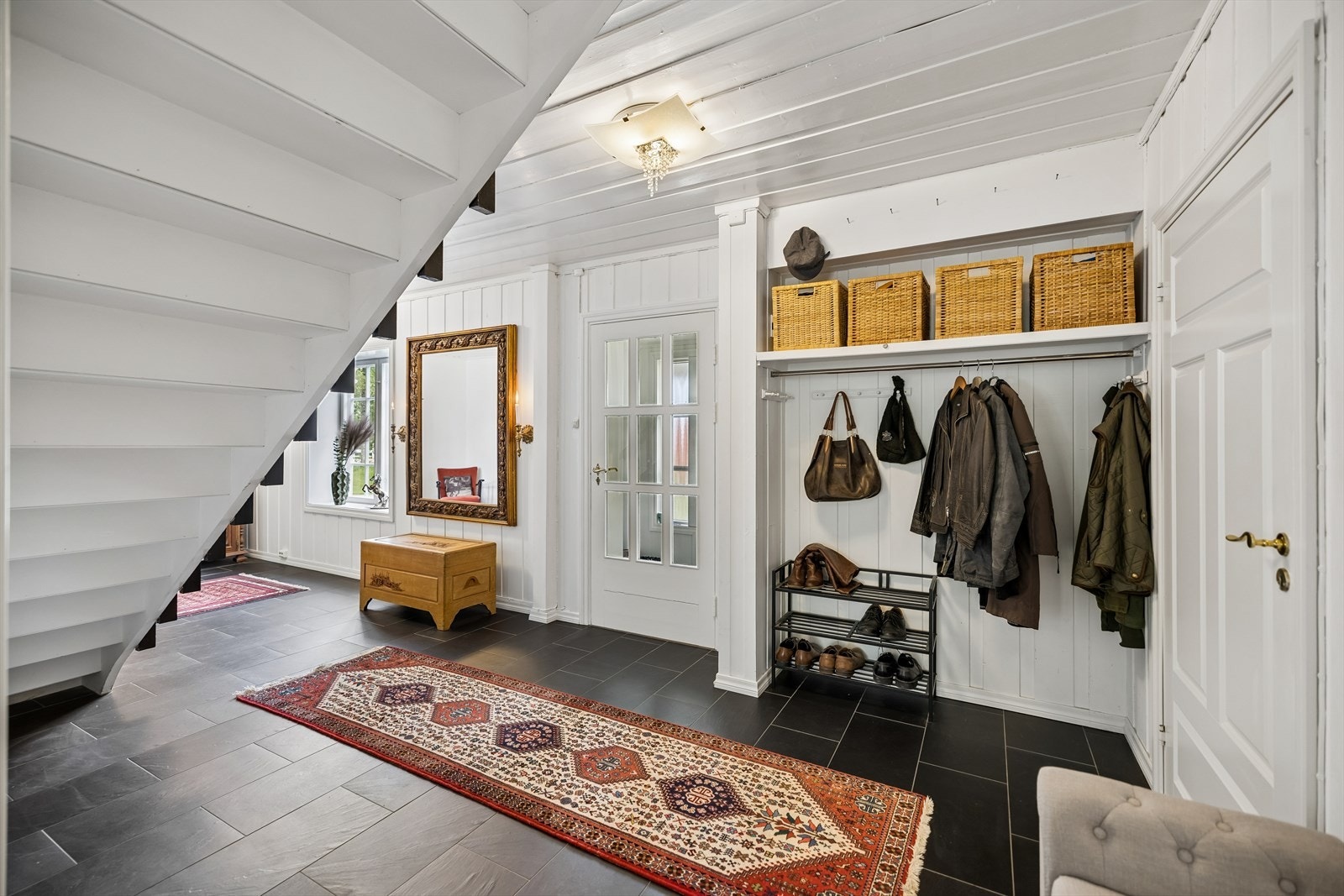 Romslig hall med god plass til oppbevaring av yttertøy og sko. Galleribilde