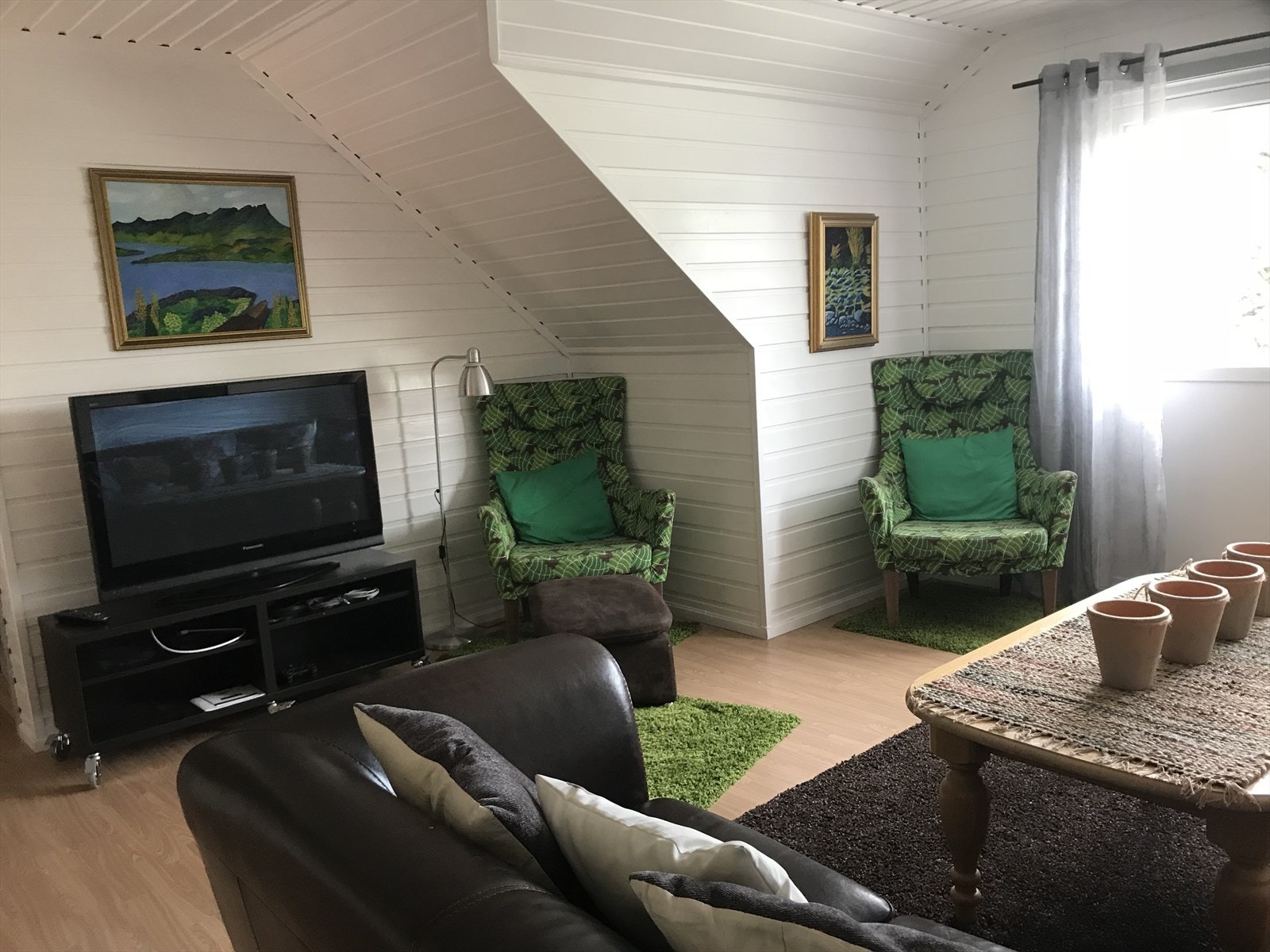 Stuen har plass til både TV-krok og en liten sittegruppe. Selgers foto. Galleribilde