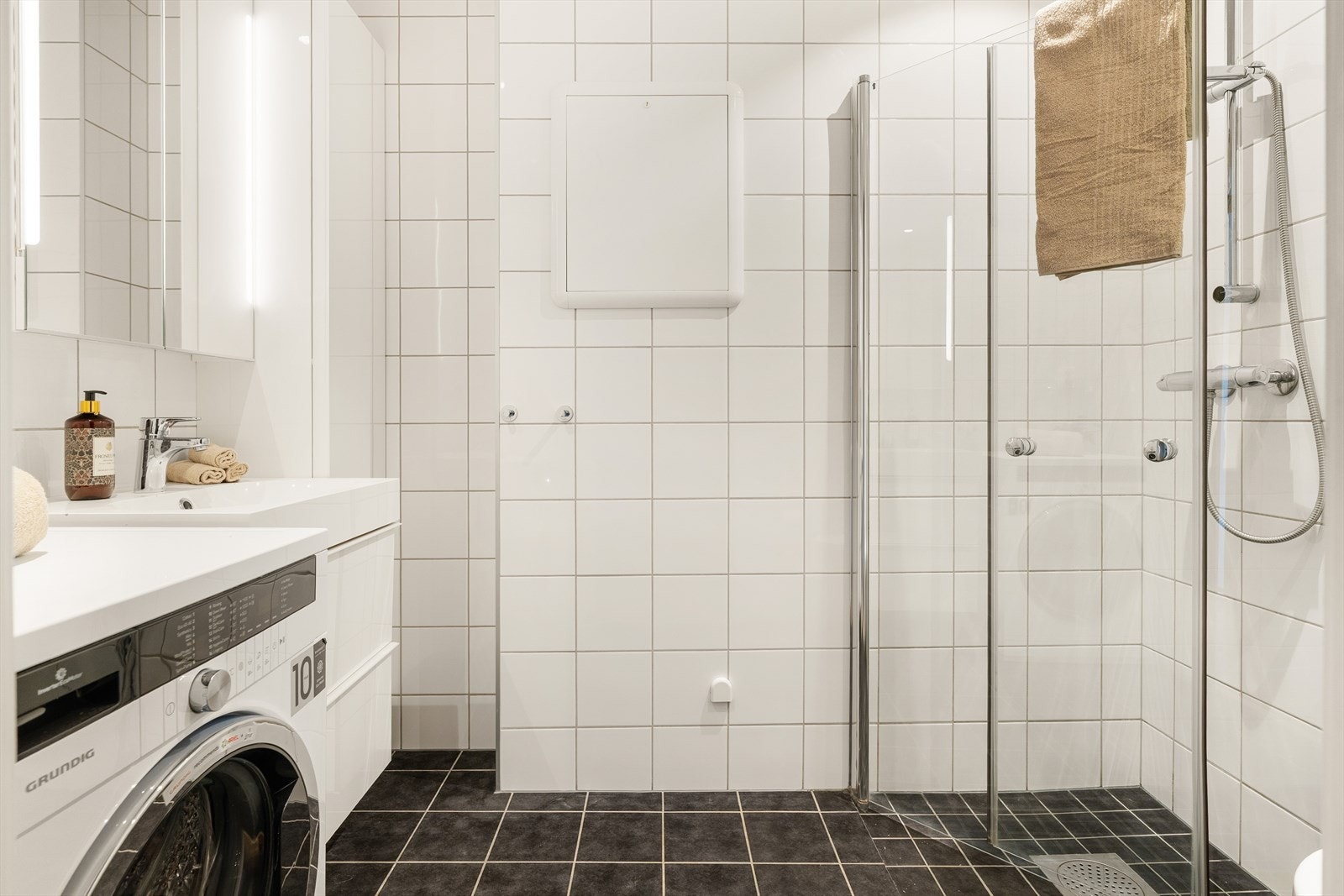 Stilrent og flislagt bad med behagelig varme i gulv. Opplegg for vaskemaskin. Galleribilde