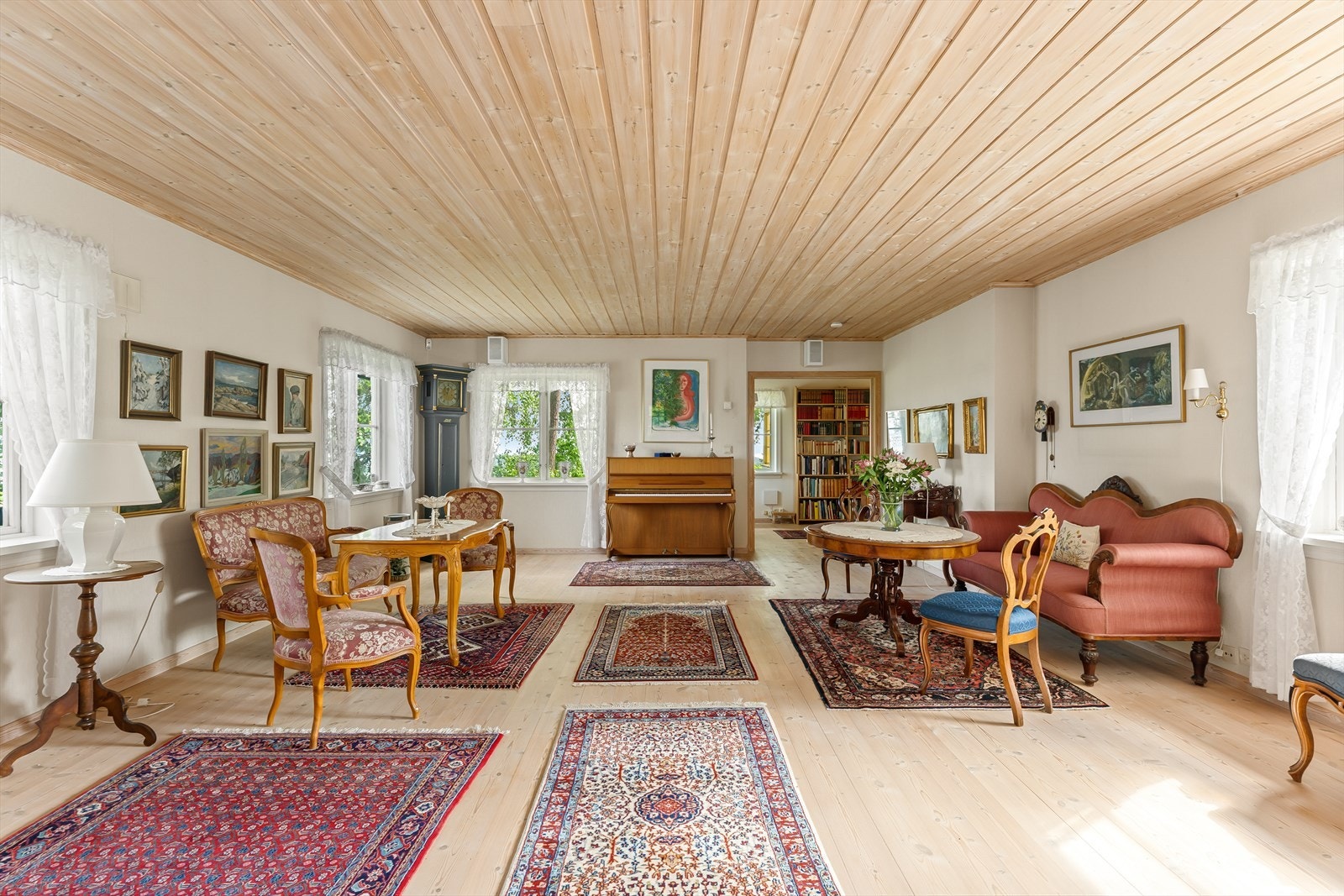 Stor og lys stue med originale tregulv og god plass til flere sittegrupper. Galleribilde