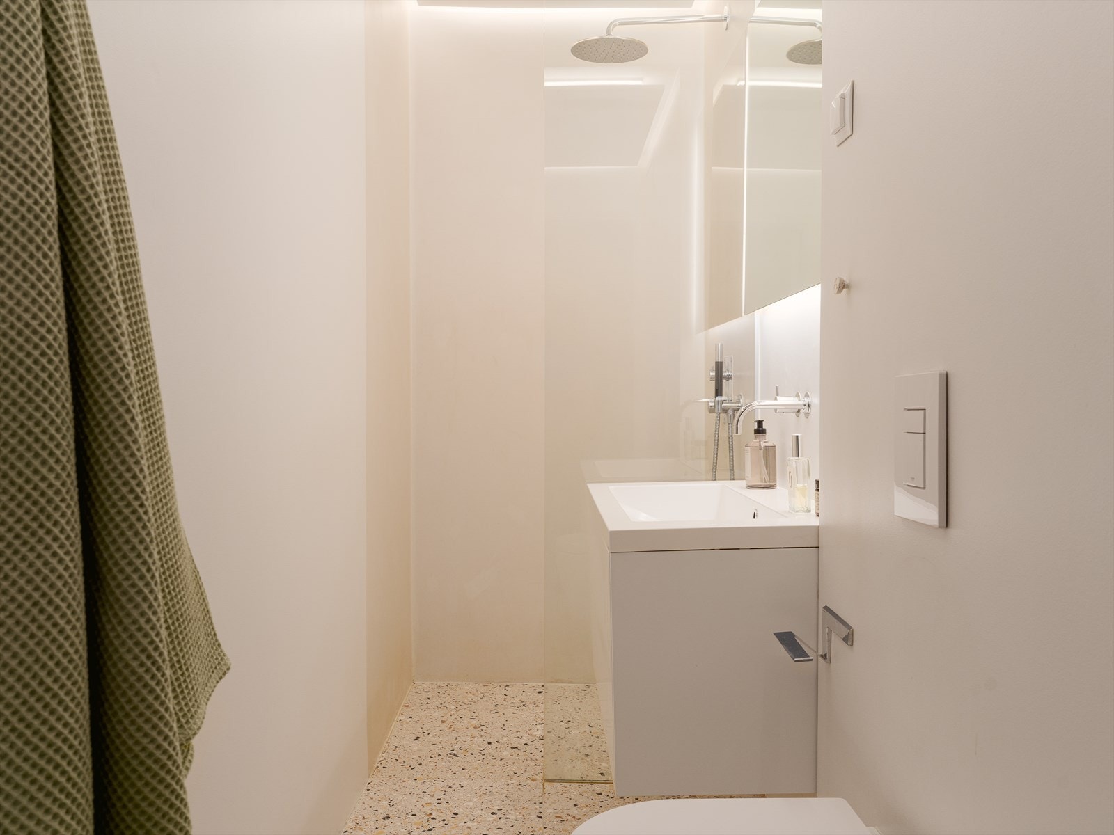 I dusjsonen er veggene kledd med mikrosement, som gir en sømløs og moderne finish. Galleribilde