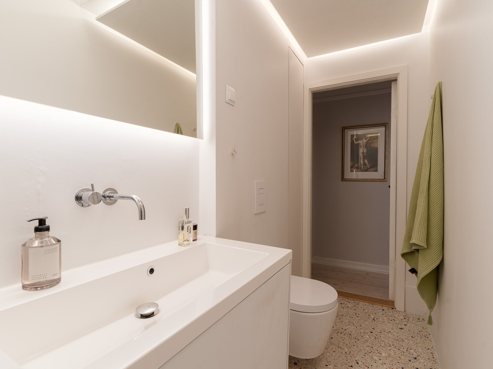 Badet er utstyrt med vegghengt toalett, servantinnredning og integrert belysning i himlingen. Galleribilde