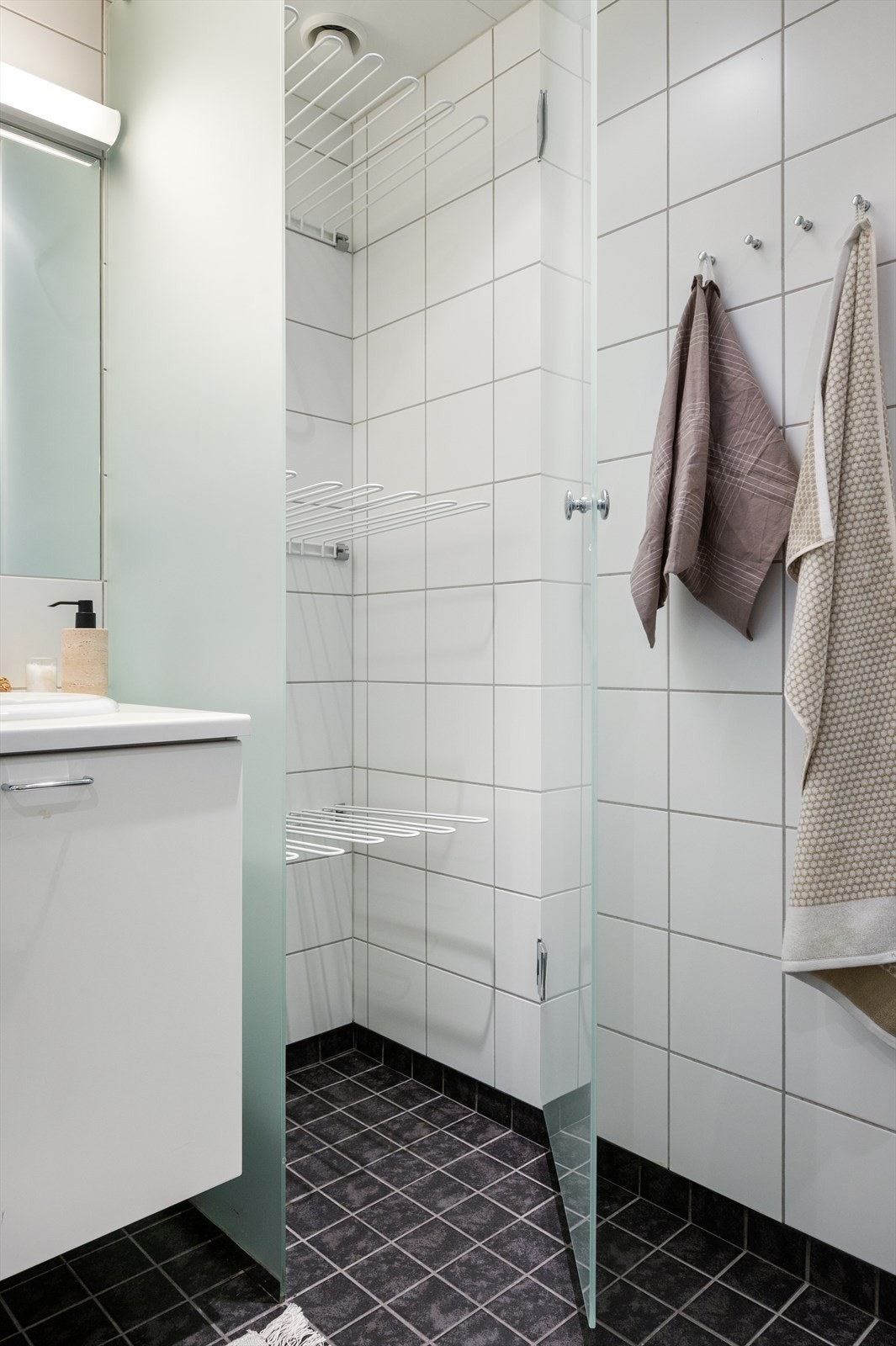 Badet er flislagt med varme i gulv og har et praktisk tørkeskap. Galleribilde