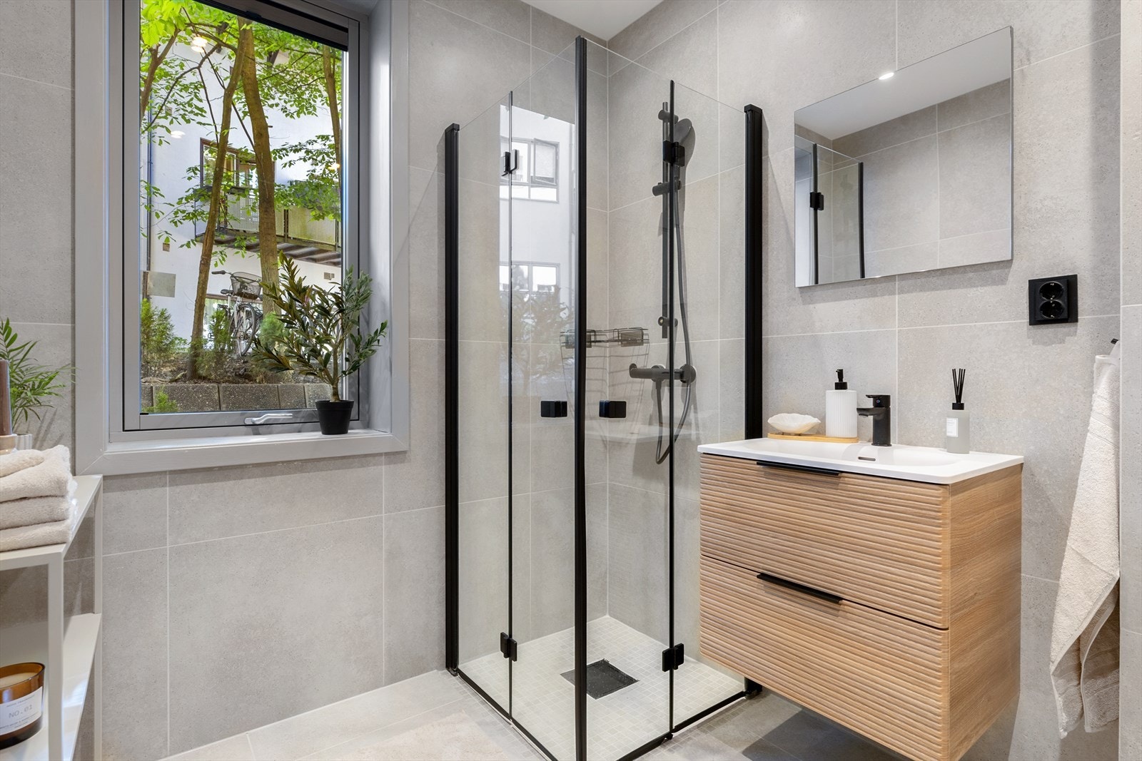 Badet er fra 2021 og fremstår meget lekkert. Det er innredet med servant, vegghengt toalett og dusj med innfellbare glassdører. Galleribilde