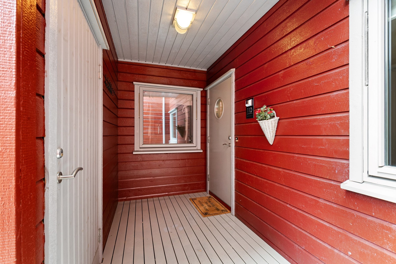 Innbydende inngangsparti med rød trefasade og lys grå dør, ideelt for et koselig hjem med sjarm. Galleribilde