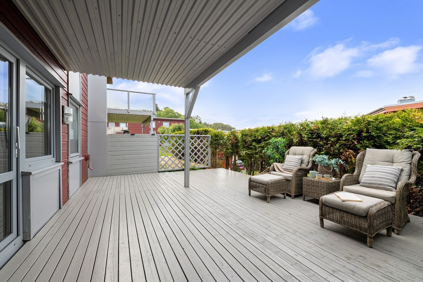 Romslig terrasse med overbygg, perfekt for avslapning. Velholdt område omgitt av frodig vegetasjon gir privatliv. Galleribilde