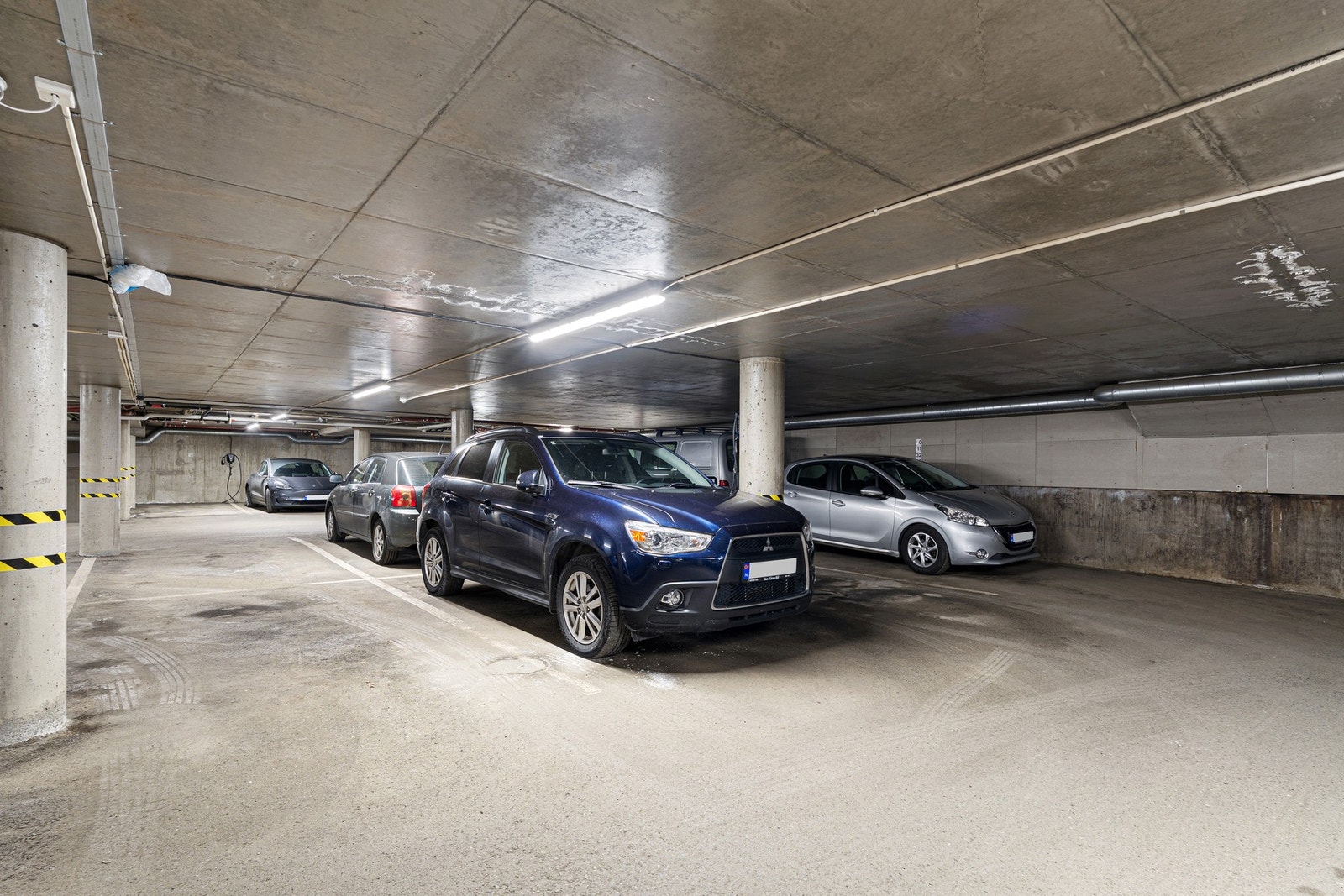 Andelen disponerer en egen parkeringsplass i felles oppvarmet P-kjeller. Her er det mulig å etablere eget ladepunkt for elbil. Galleribilde