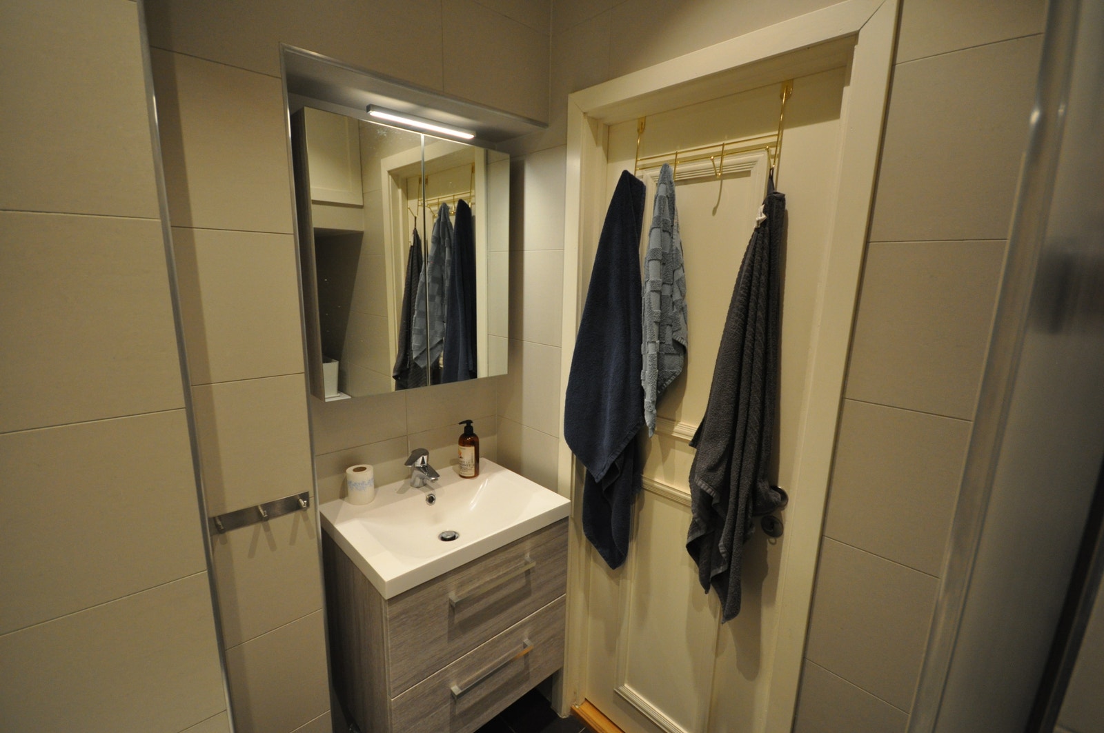 Flislagt bad med varmekabler og dusjnisje. Det er plass til vaskemaskin og tørketrommel. Galleribilde