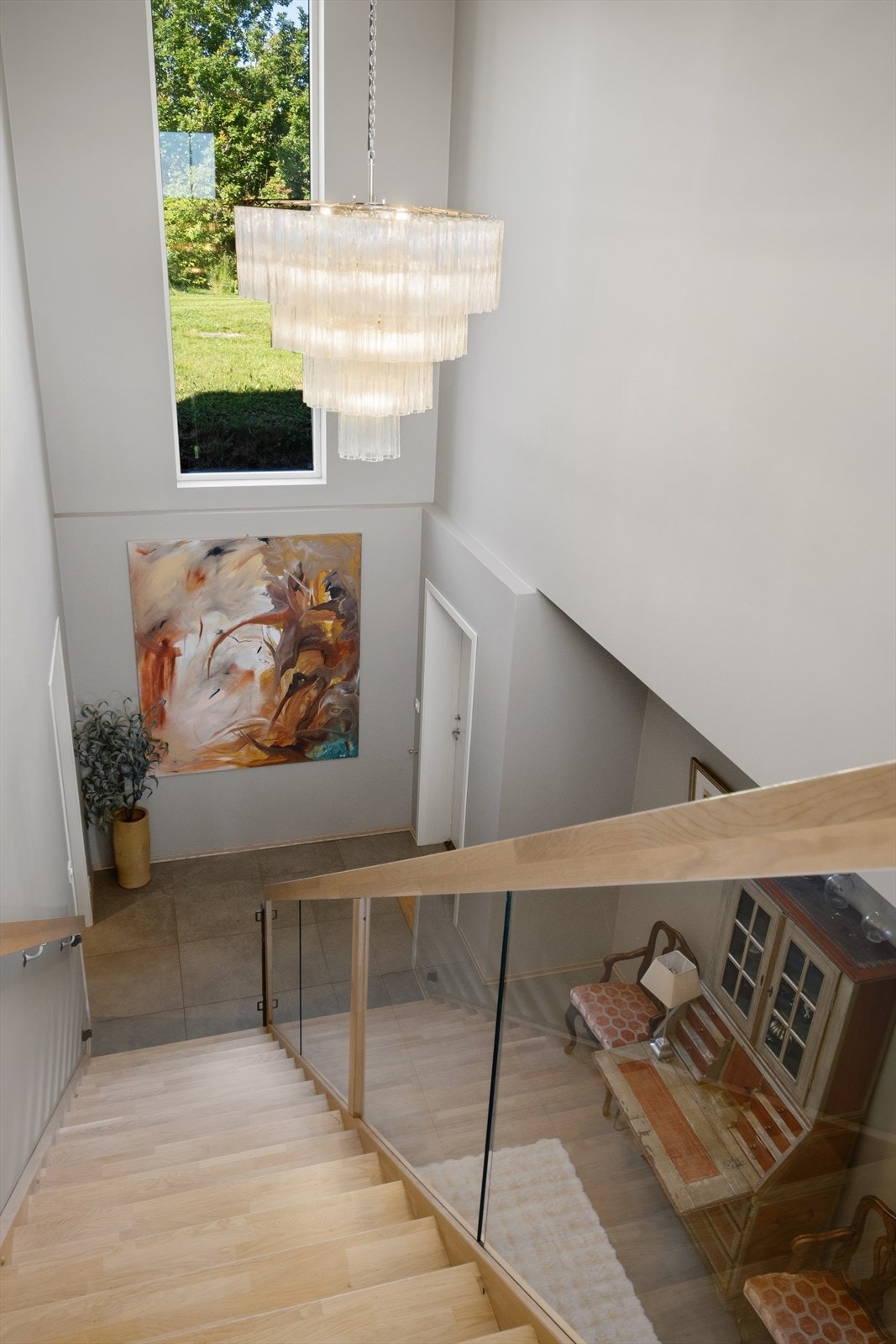 Trappen i tre med glassrekkverk er et sentralt designelement som binder de to etasjene sammen. Galleribilde