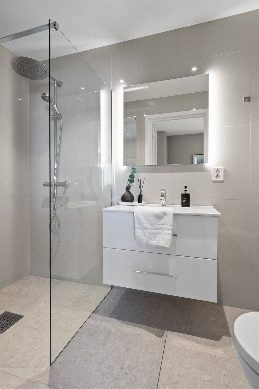 Et av to bad i overetasjen, helfliset med gulvvarme, dusj med glassvegg og downlights i taket. Galleribilde