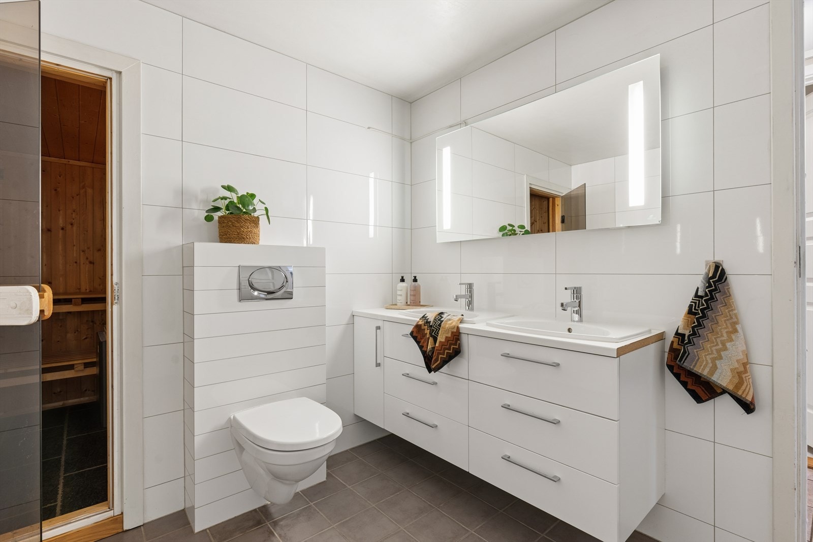 Badet i underetasjen er innredet med to nedfelte servanter, veggmontert toalett og dusjløsning, og fremstår som romslig og delikat. Galleribilde