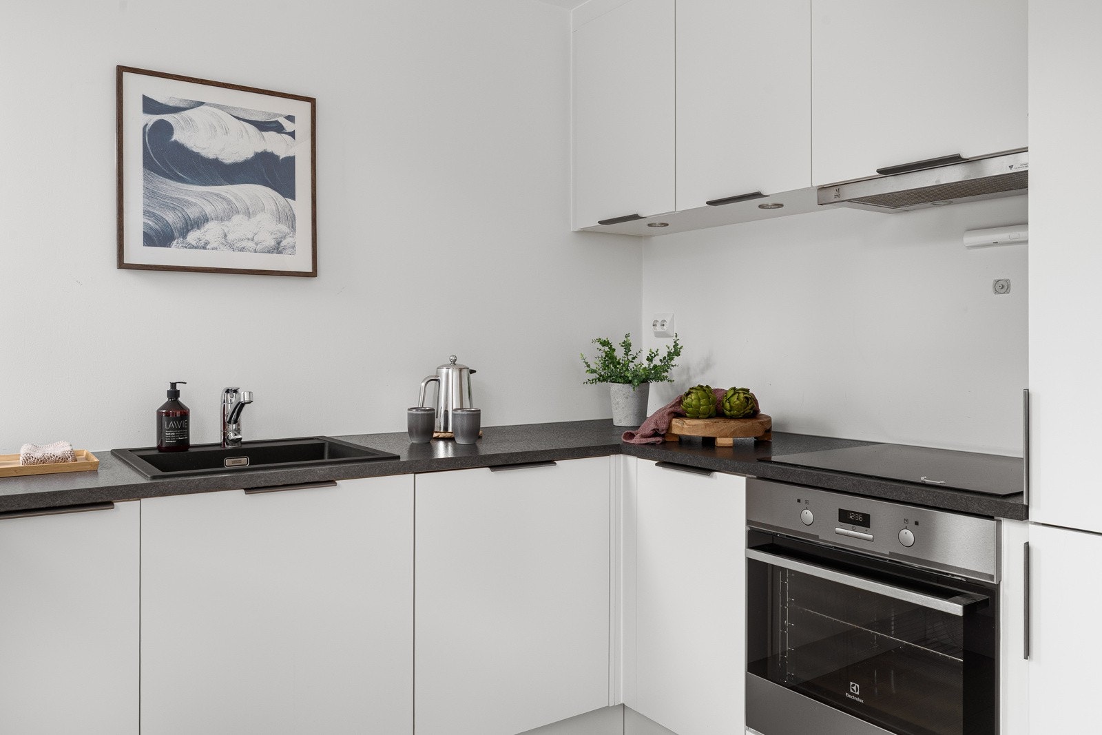 Kjøkkenet har glatte fronter og benkeplate av laminat. Integrerte hvitevarer som kjøl/fryseskap, oppvaskmaskin, induksjonstopp og stekeovn. Galleribilde