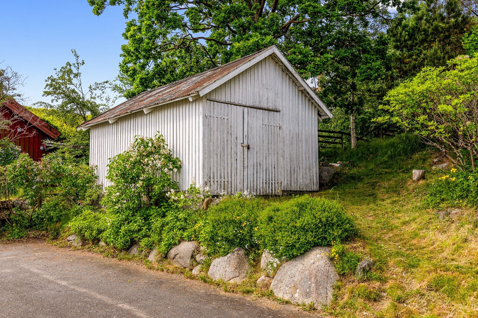 Uthuset/tidligere garasje på eiendommen har behov for rehabilitering. Det er ikke innkjøringsmuligheter til denne i dag. Galleribilde