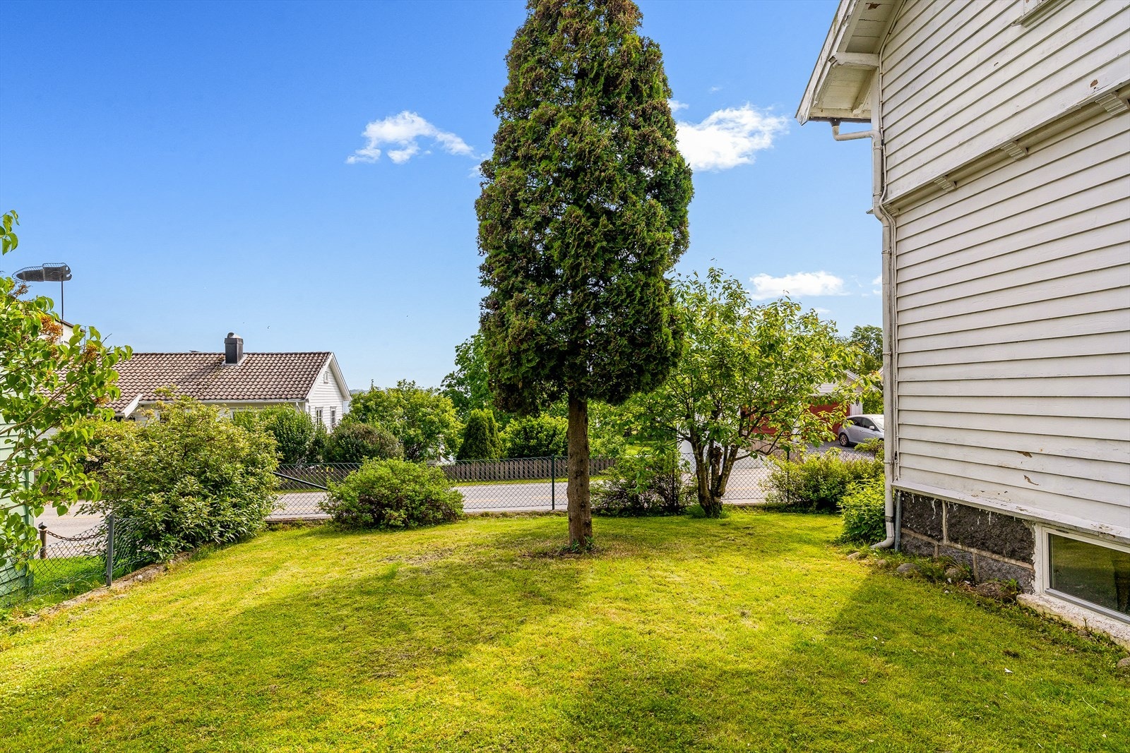 Stor og relativt flat hage med plen og enkel beplantning. Galleribilde