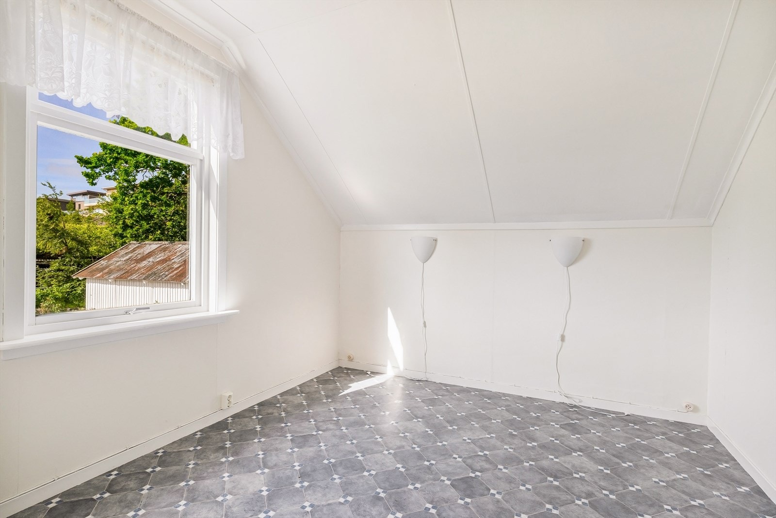 Et lyst rom med skråtak som kan benyttes som soverom eller kontor. Galleribilde